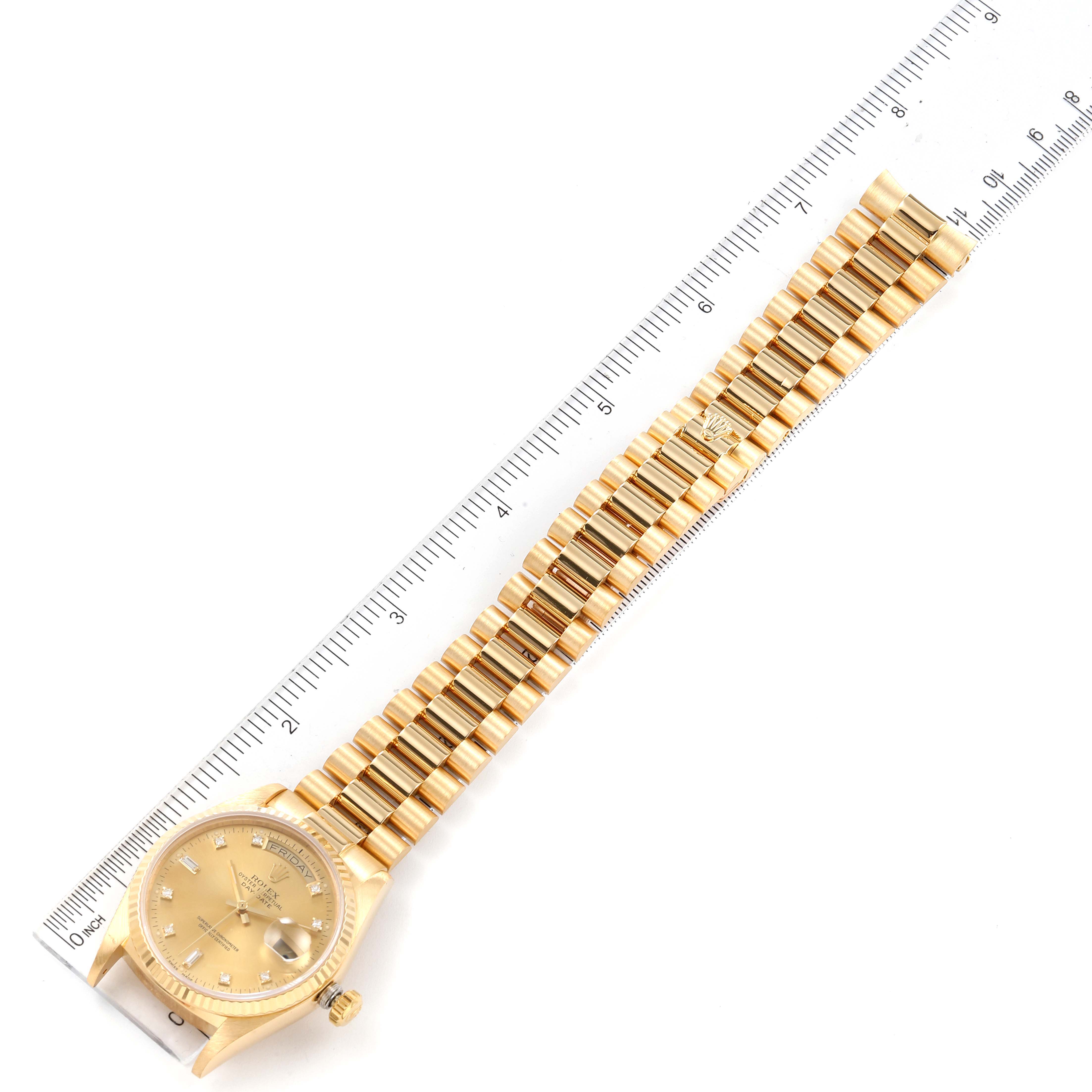 The image shows a top-down view of a Rolex President 18038 Men
s Yellow Gold Champagne Dial 18038 Men
s Yellow Gold Champagne Dial model watch, including the face, bezel, and full bracelet, next to a ruler.