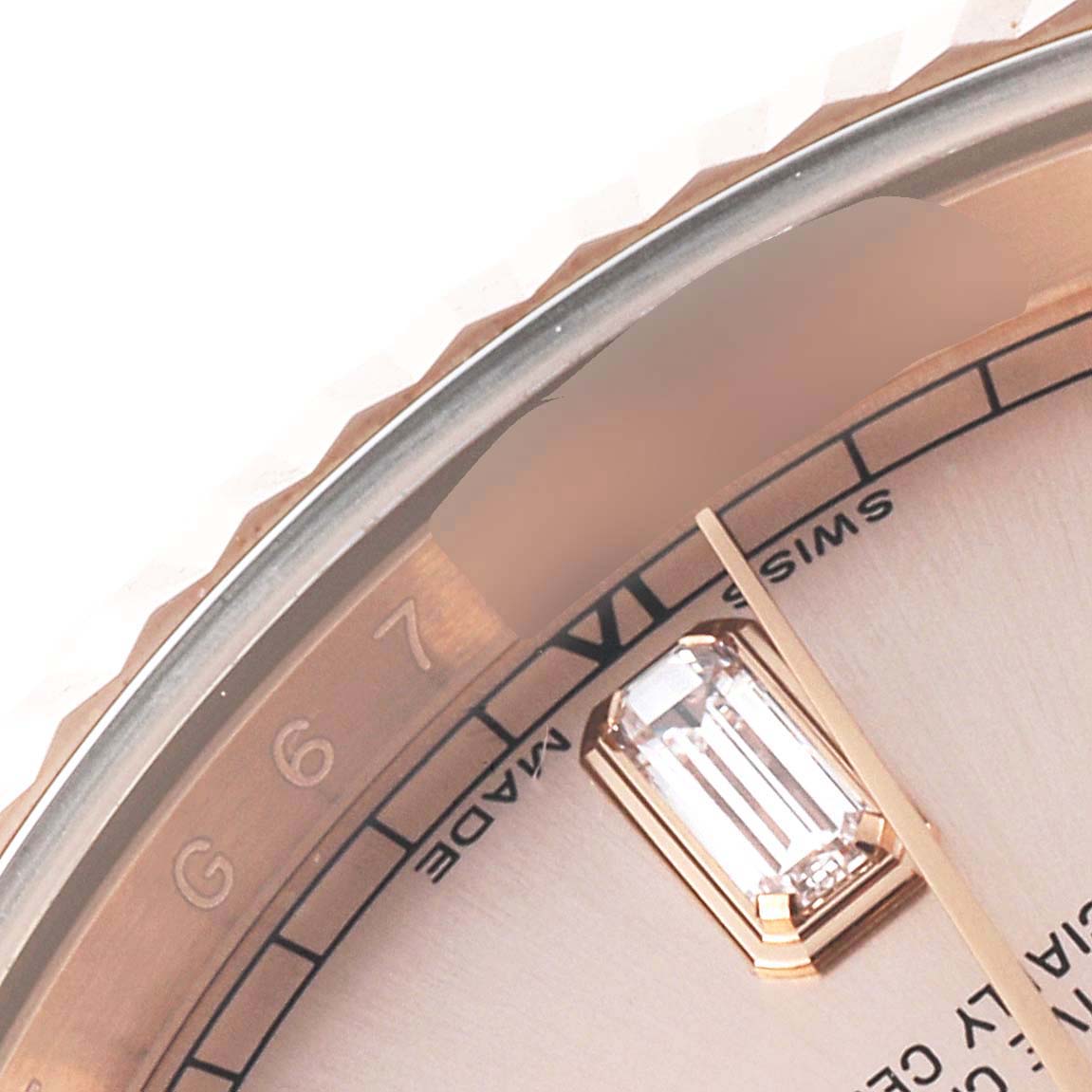 This close-up image of the Rolex President 118235 Men's Rose Gold Pink Dial 118235 Men's Rose Gold Pink Dial watch showcases part of its dial, indices, and bezel.
