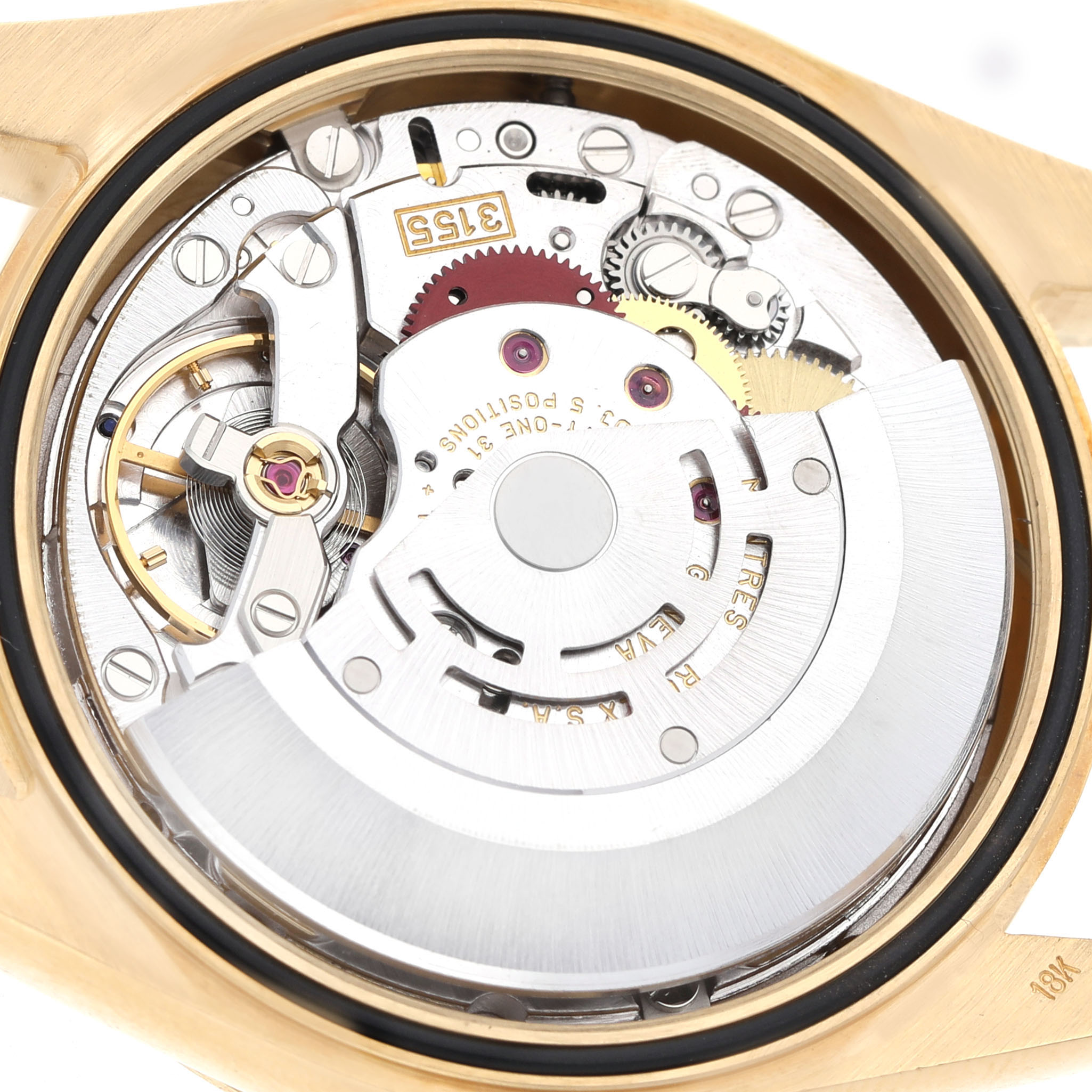 The image shows the internal movement of the Rolex President 118238 Men's Yellow Gold Black Dial model from the back, highlighting gears and mechanical components.