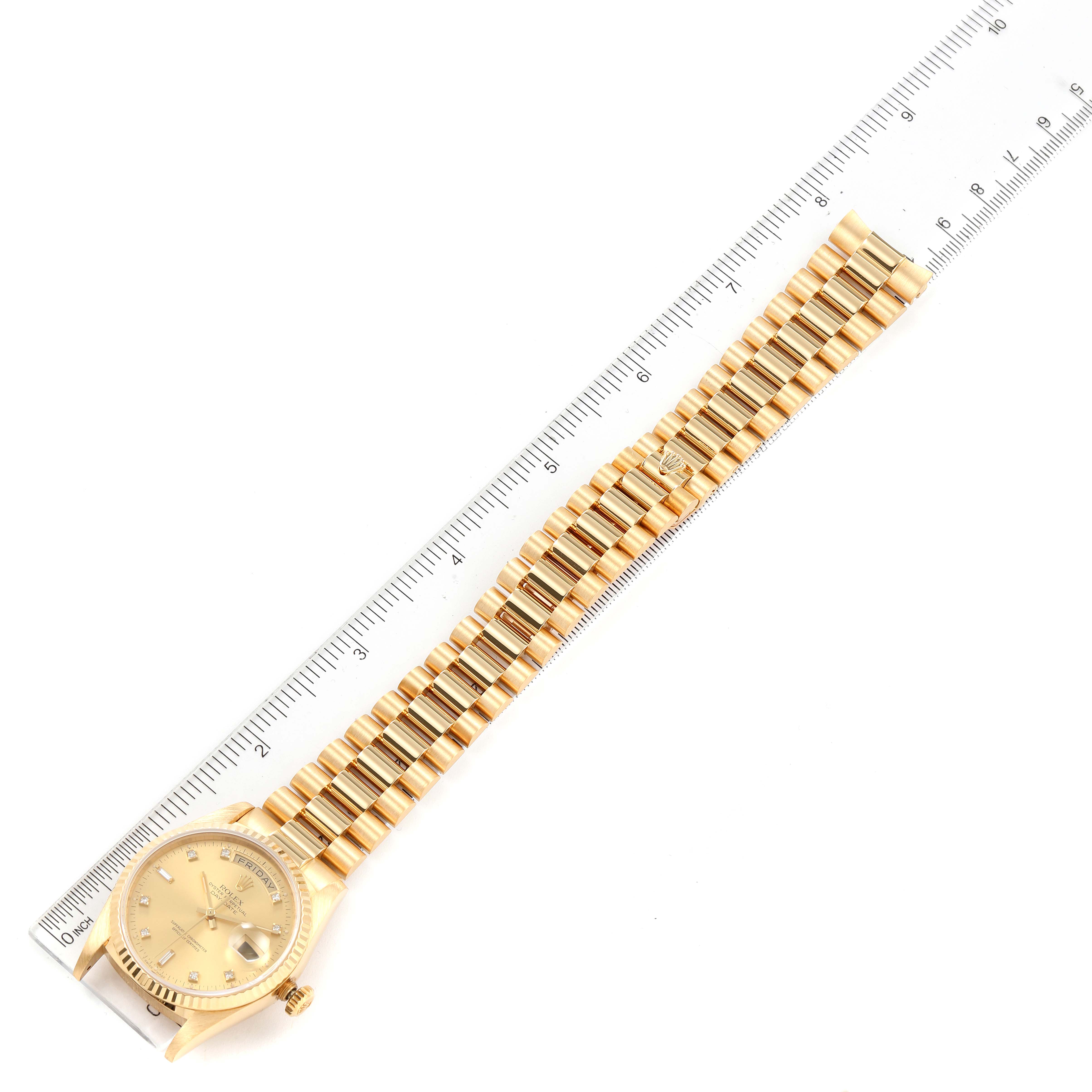The image shows a Rolex President 18238 Men
s Yellow Gold Champagne Dial 18238 Men
s Yellow Gold Champagne Dial model watch laid flat with its full band alongside a ruler for size reference.