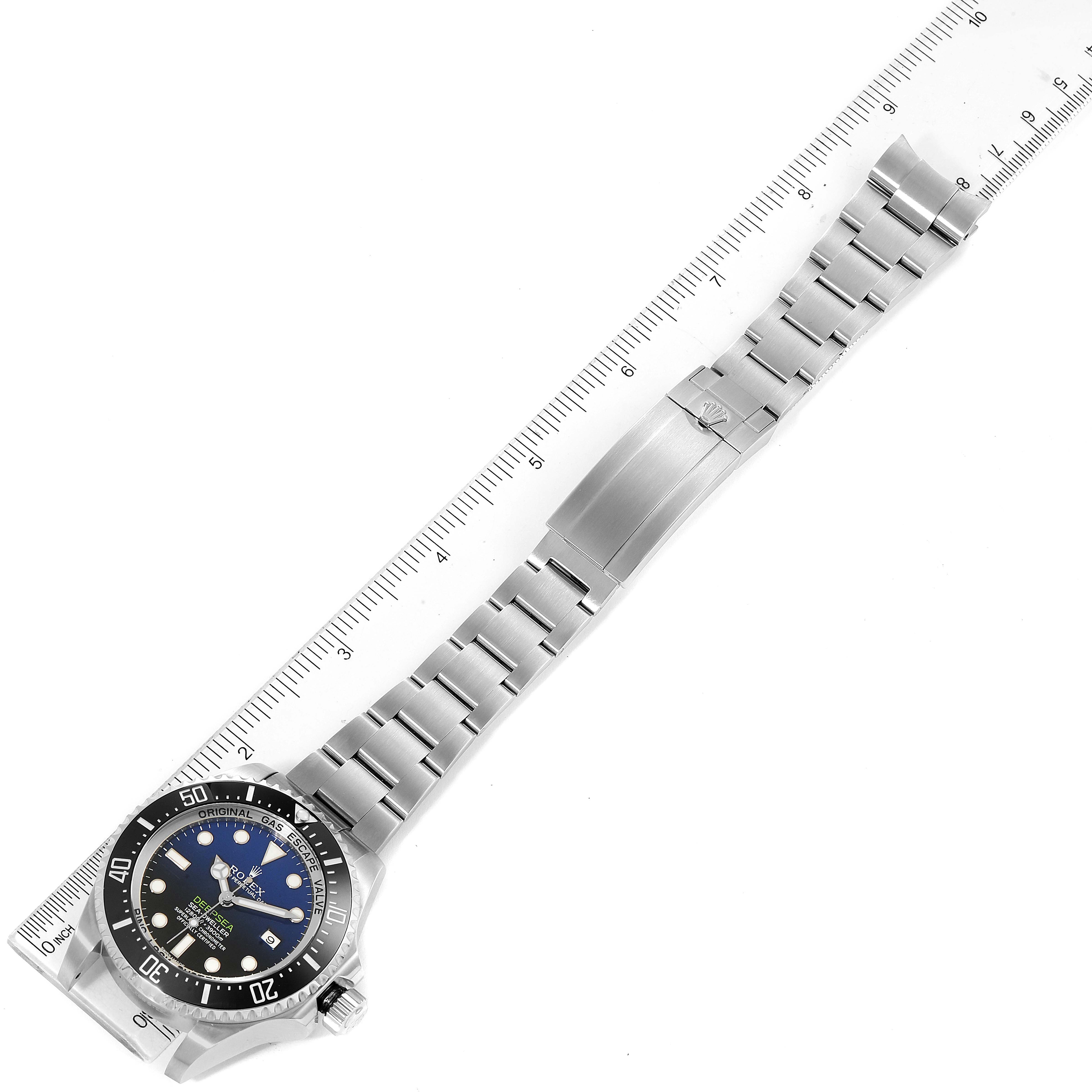 This image shows a top-down view of a Rolex Sea-Dweller 116660 Men's Stainless Steel Blue Dial 116660 Men's Stainless Steel Blue Dial watch, displaying its face, bezel, bracelet, and clasp laying beside a ruler.