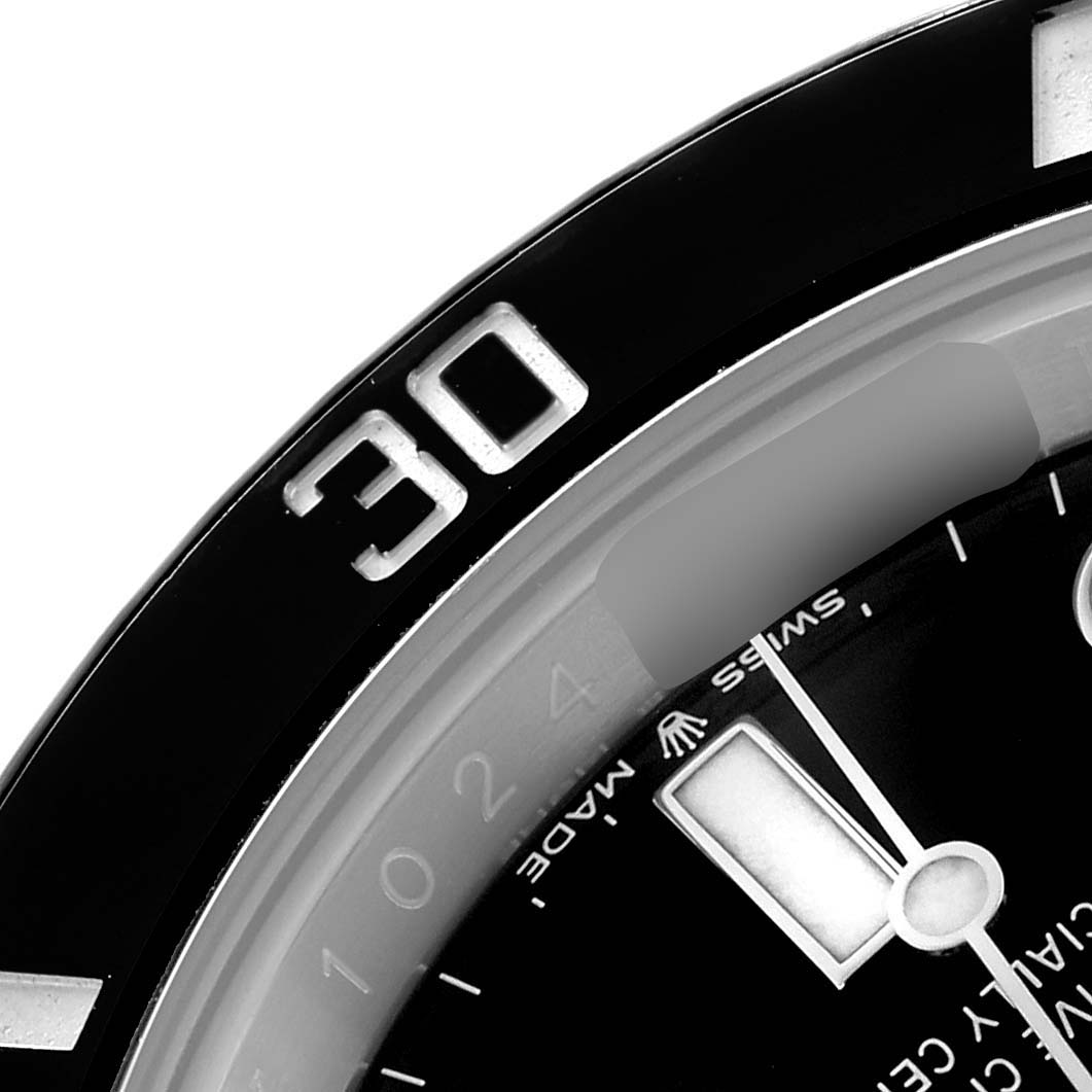 The image shows a close-up of the Rolex Submariner 126610 Men
s Stainless Steel Black Dial
s bezel, part of the dial, and minute hand at an angled view.