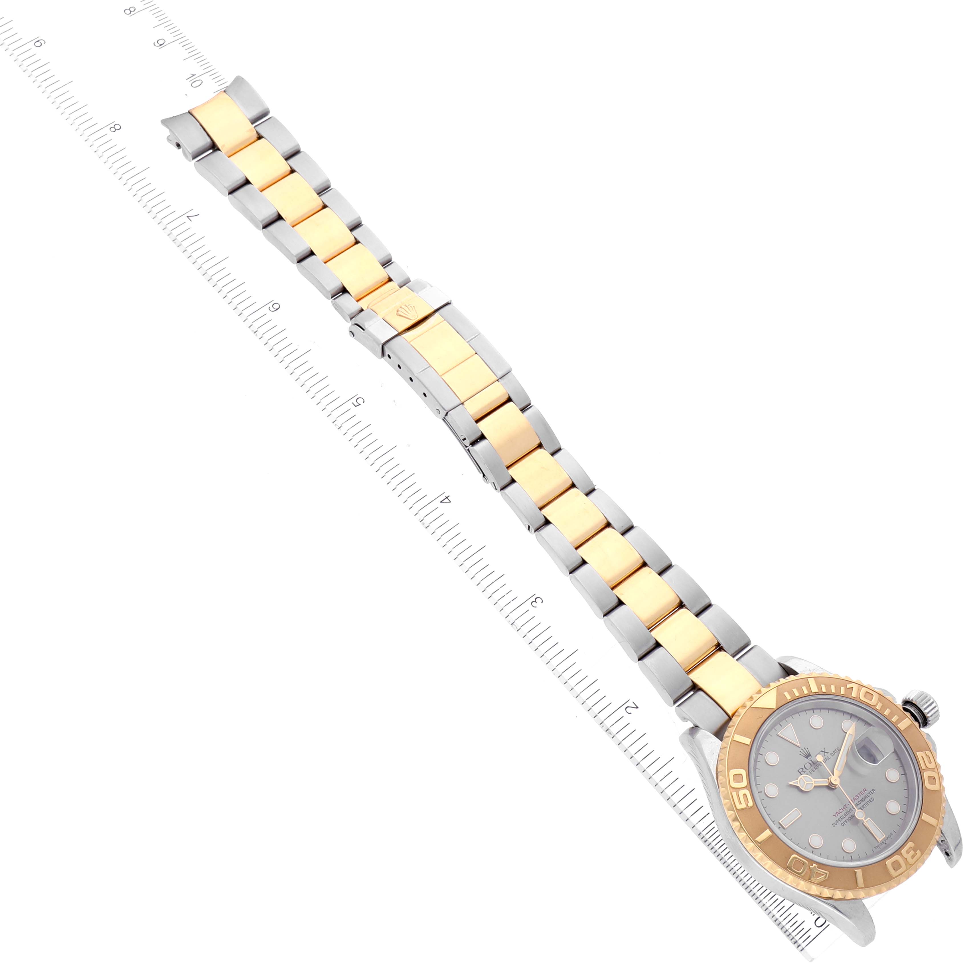 The image shows a top-down view of a Rolex Yacht-Master 16623 Men's Steel and Gold (two tone) Grey Dial 16623 Men's Steel and Gold (two tone) Grey Dial watch, highlighting its face, crown, and two-tone bracelet with a measuring ruler.