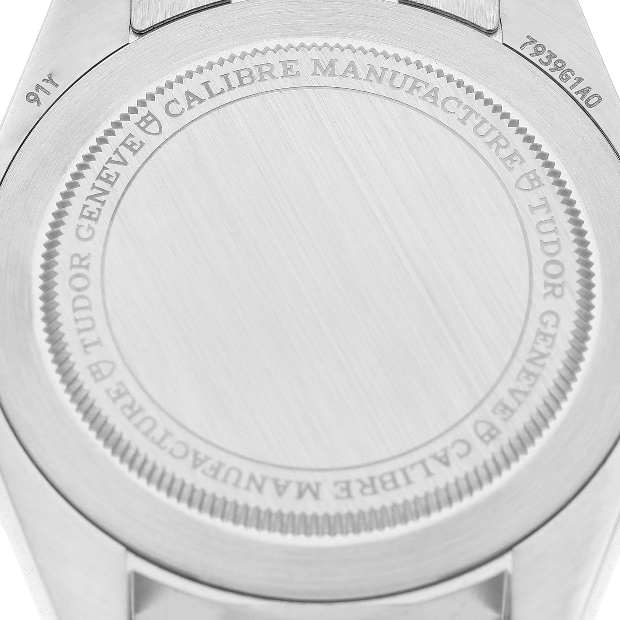 The image shows the case back of the Tudor Heritage Black Bay 7939G Men's Stainless Steel Black Dial watch, featuring engraved branding and model details.