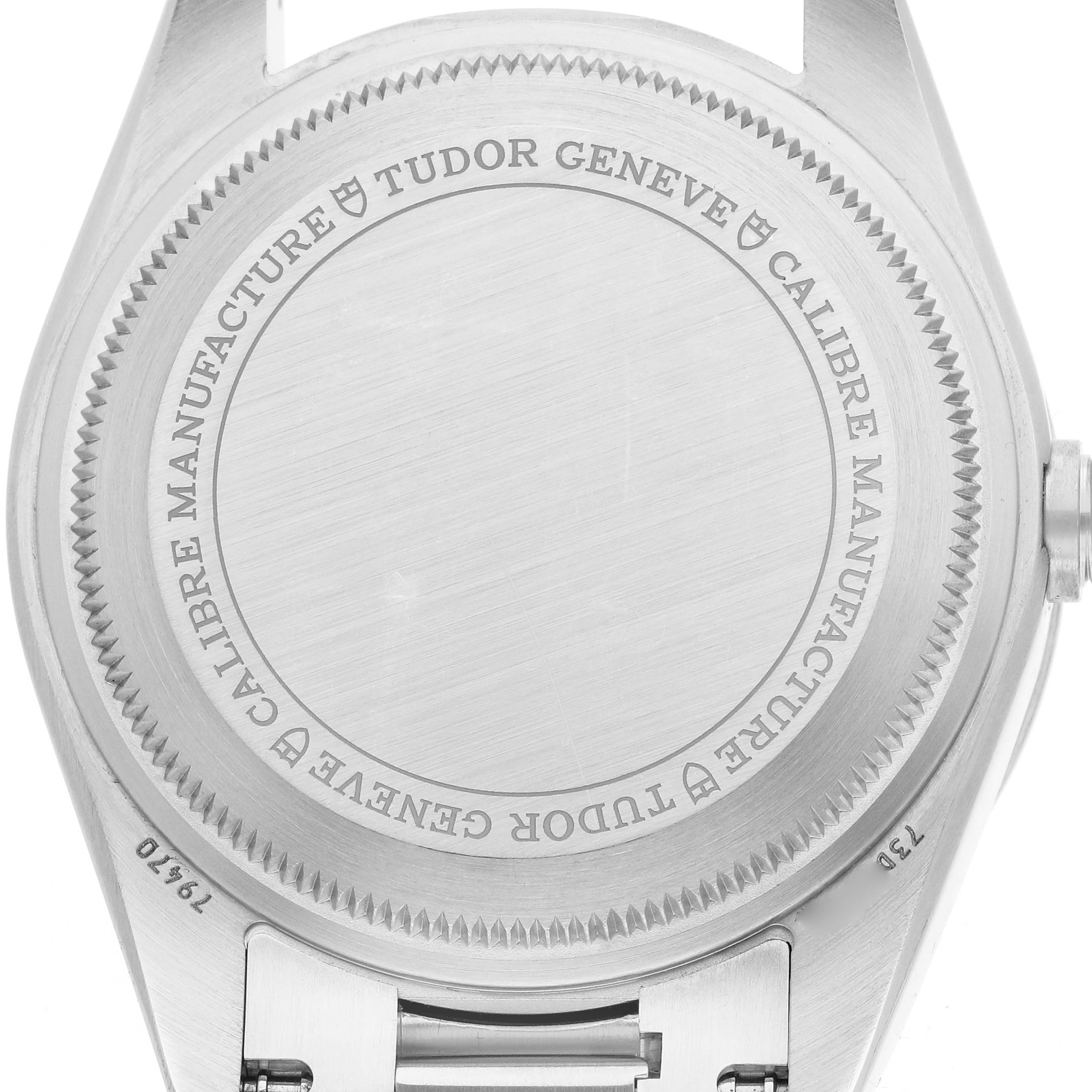 The image shows the back case of a Tudor Heritage Black Bay 79470 Men
s Stainless Steel Black Dial watch with engraved details and a visible crown.