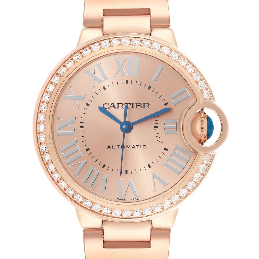 The Cartier Ballon Bleu WJBB0077 Women's Rose Gold Pink Dial watch is shown from a front angle, featuring a diamond bezel, blue hands, and Roman numeral markers.