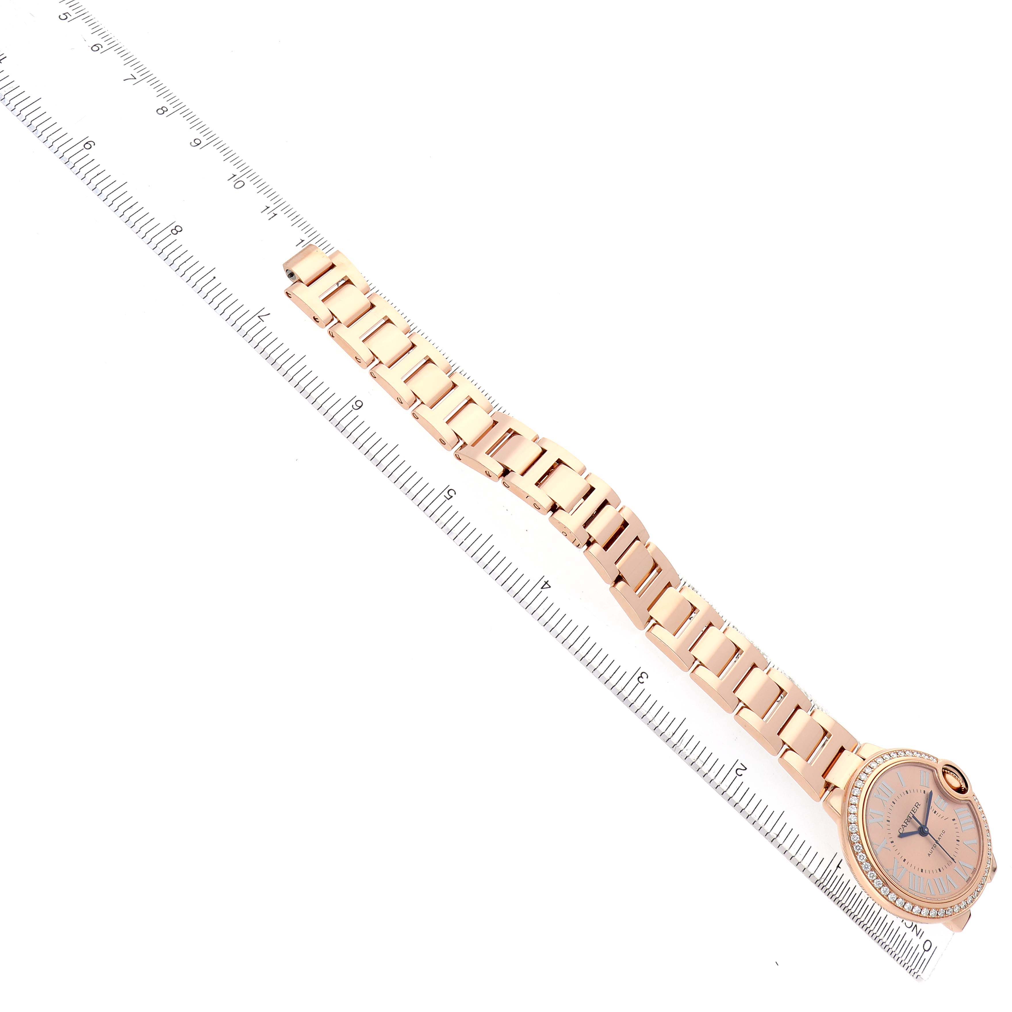 The Cartier Ballon Bleu WJBB0077 Women's Rose Gold Pink Dial watch is displayed diagonally, showing the face, bezel, and full bracelet alongside a ruler for scale.