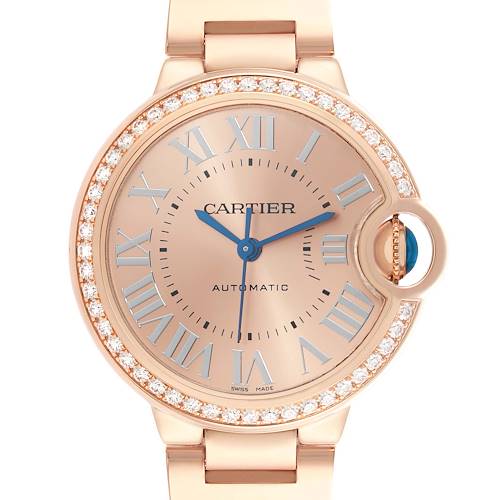 The Cartier Ballon Bleu WJBB0077 Women's Rose Gold Pink Dial watch is shown from a front angle, highlighting its round face, Roman numerals, and diamond-encrusted bezel.
