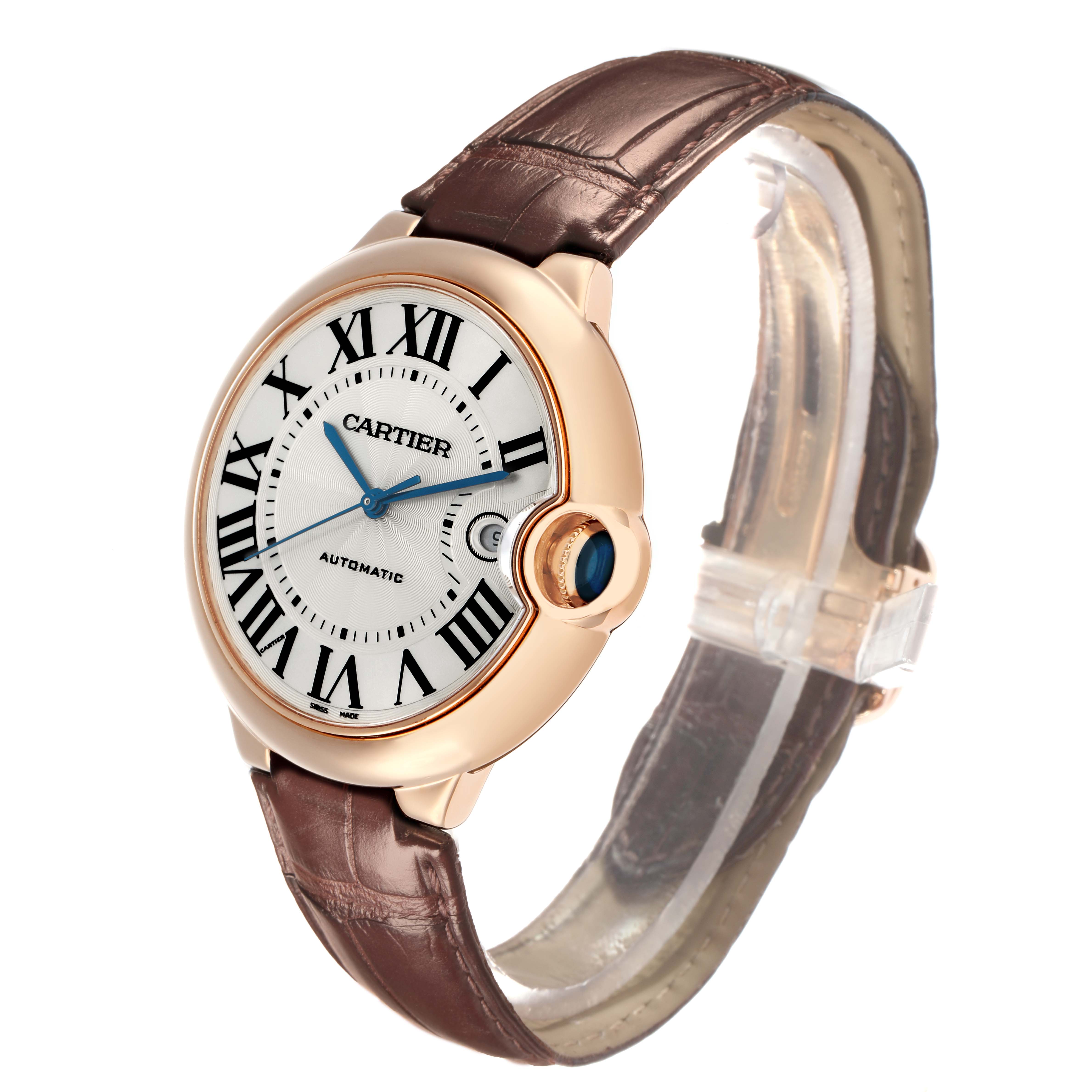 The Cartier Ballon Bleu WGBB0017 Men
s Rose Gold Silver Dial watch is shown at a tilted angle, highlighting the face, crown, and leather strap.