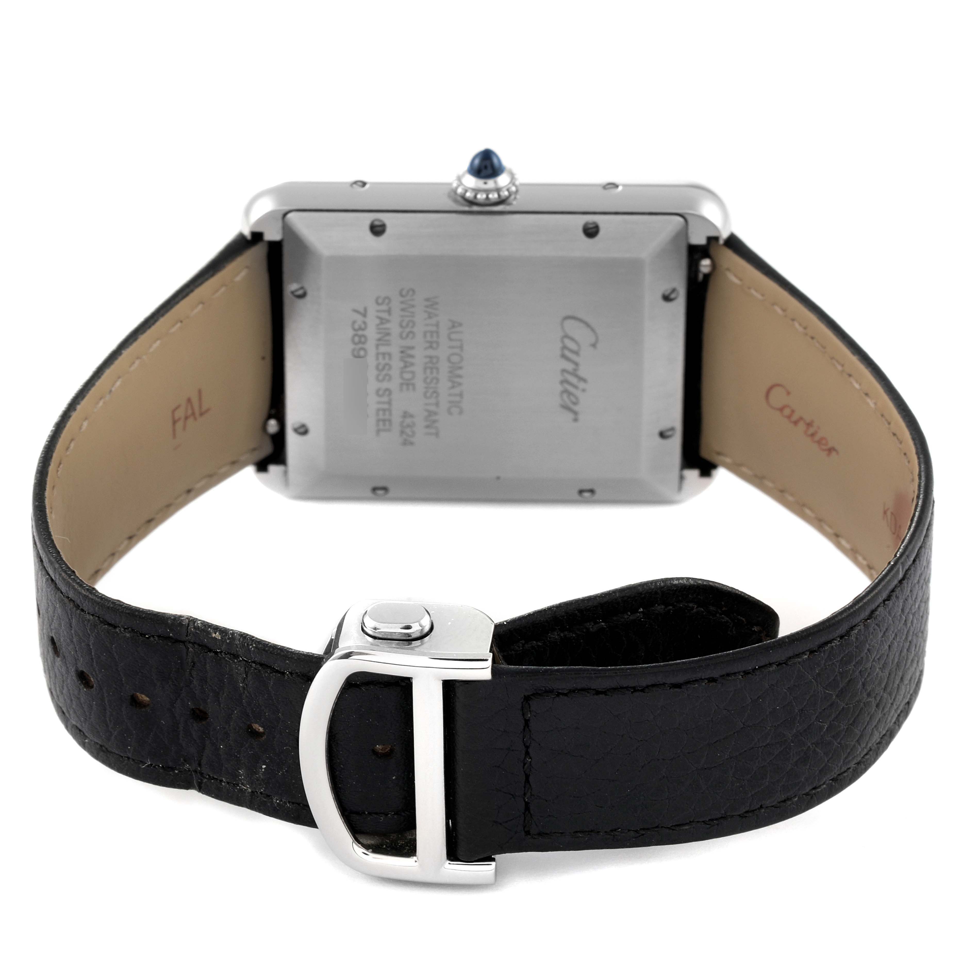 The image shows the back case and strap of a Tank Must model by Cartier, highlighting the clasp and movement details.