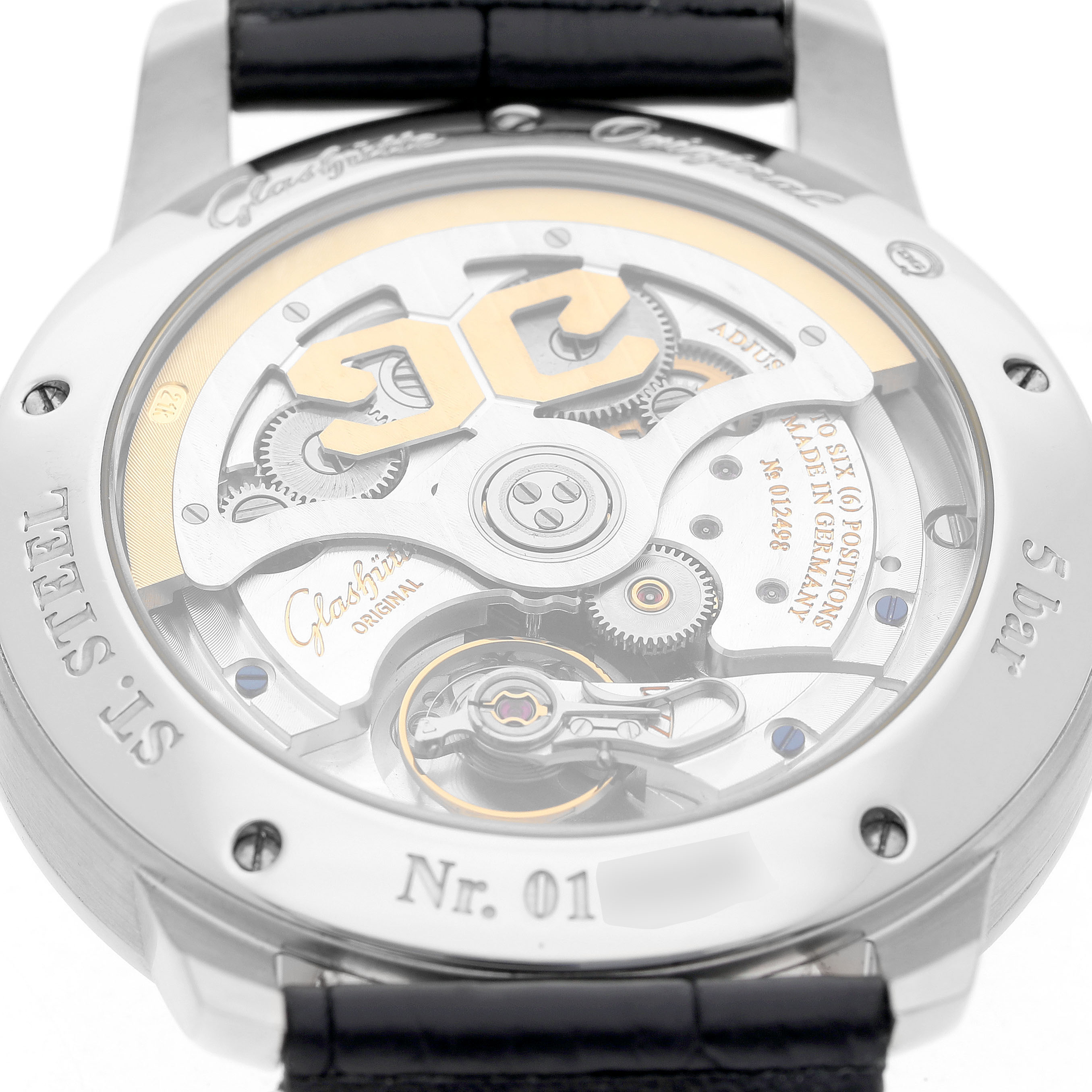 The Glashütte Original watch is shown from the back, revealing its mechanical movement and parts like gears and rotor.