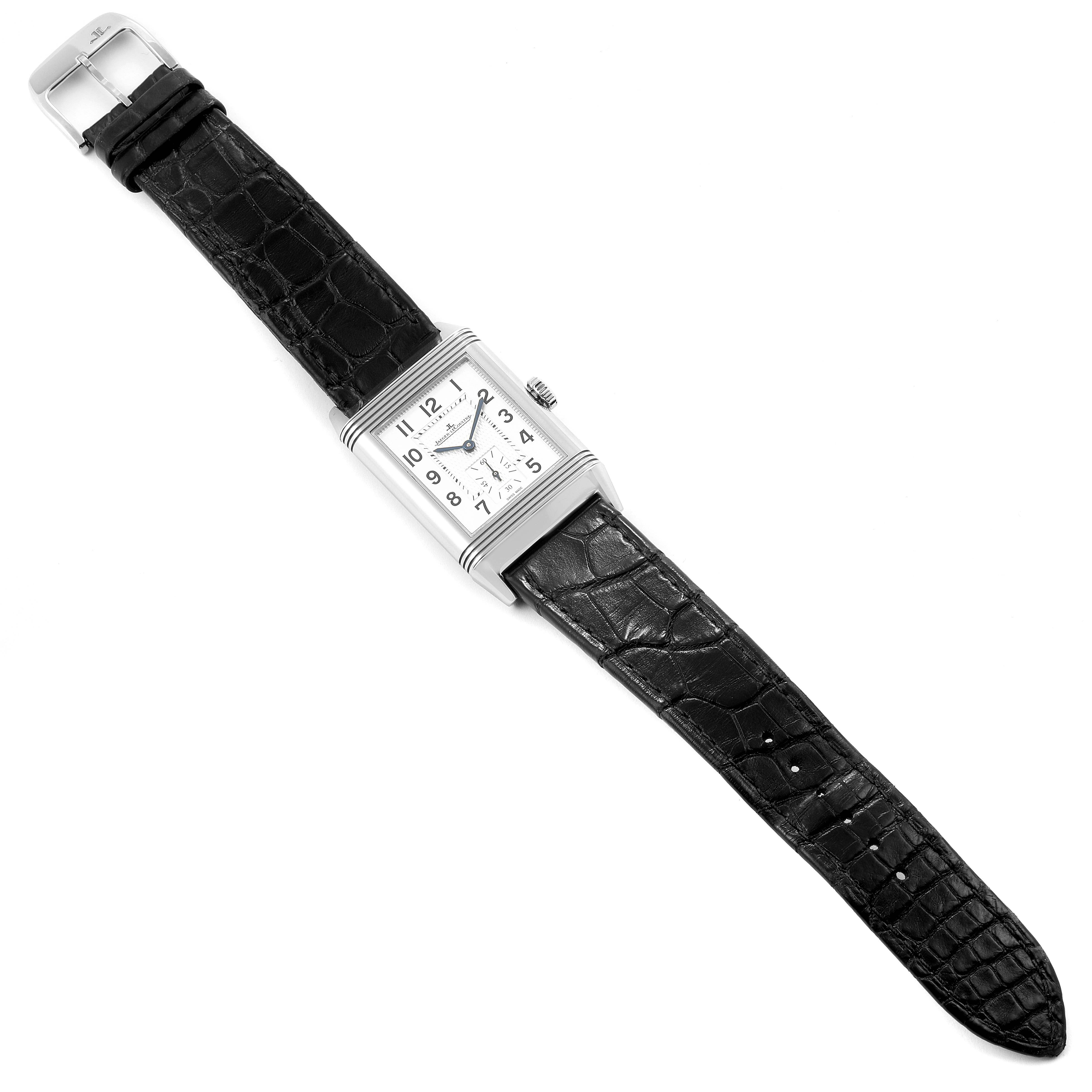 The image shows a Jaeger LeCoultre Reverso Q3858520 Men's Stainless Steel Silver Dial Q3858520 Men's Stainless Steel Silver Dial watch laid flat, displaying its rectangular dial and black leather strap.