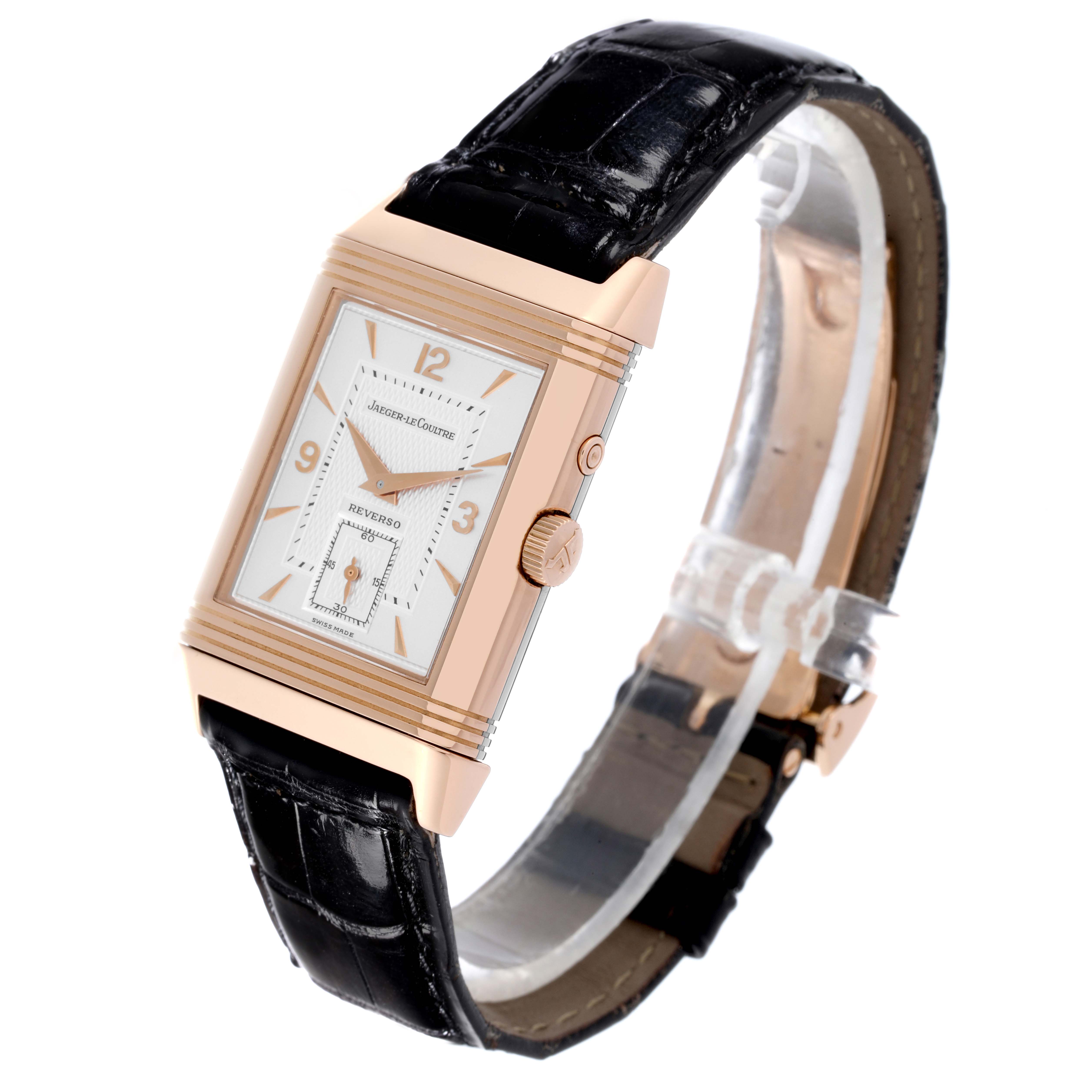The Jaeger-LeCoultre Reverso watch is shown at an angle highlighting the case, dial, crown, and leather strap.