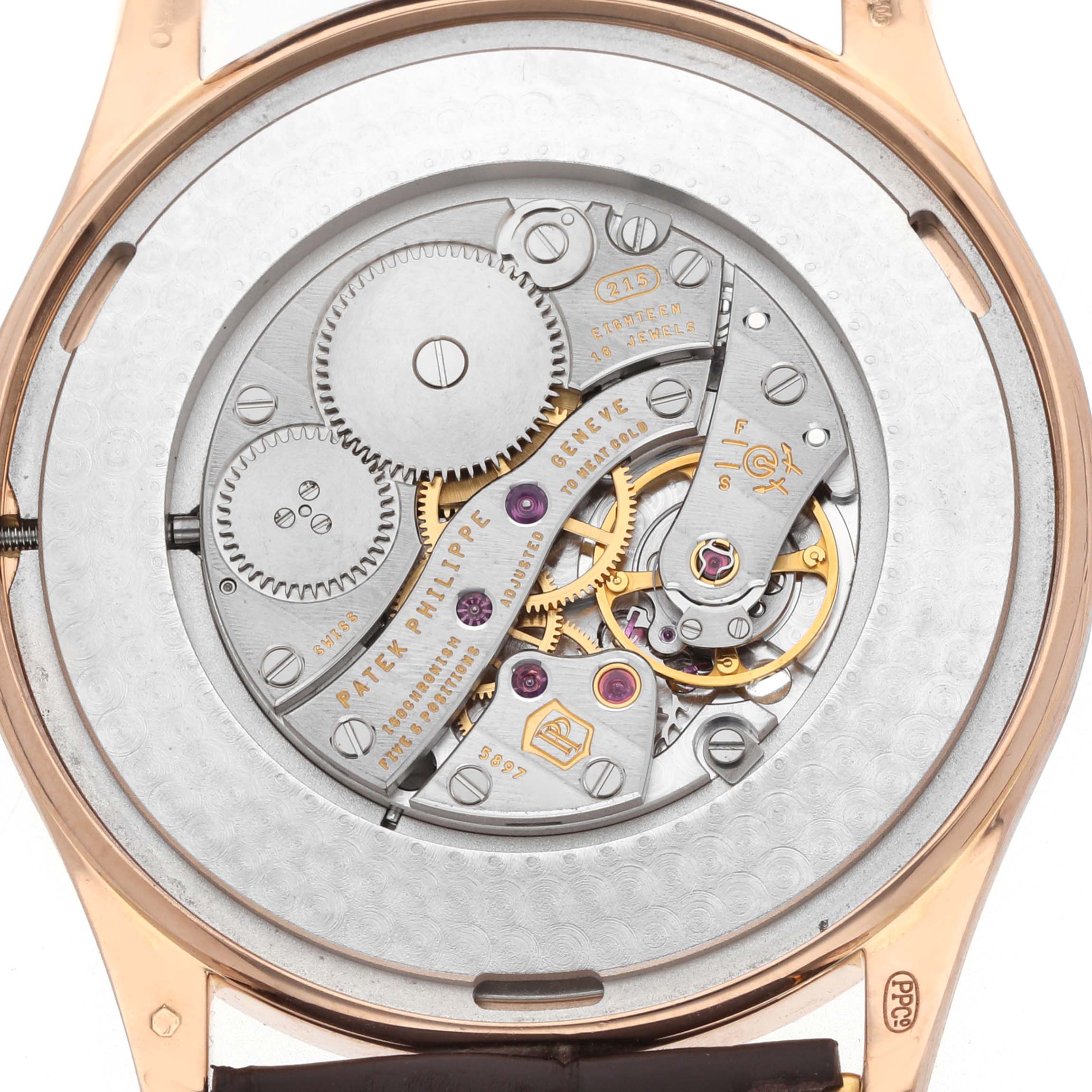 The image shows the movement of a Patek Philippe Calatrava 5196R Men
s Rose Gold Silver Dial, viewed from the back, highlighting the intricate gears and components.