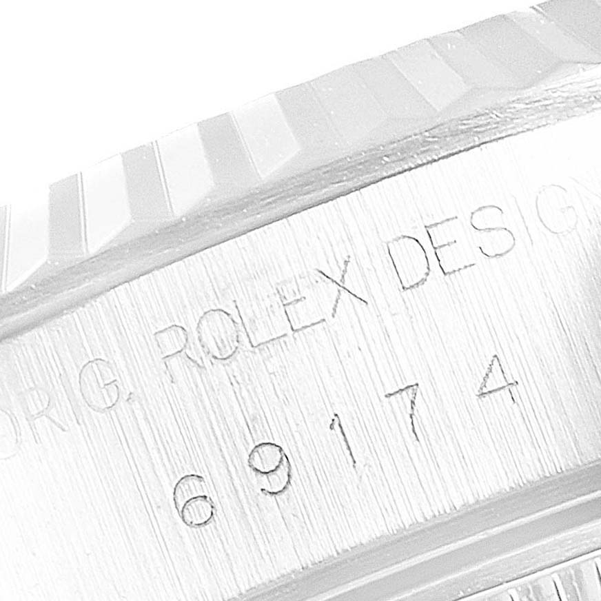 This is a close-up of the bezel and case of a Rolex Datejust 69174 Women's Stainless Steel White Dial 69174 Women's Stainless Steel White Dial, showing the engraved model number.