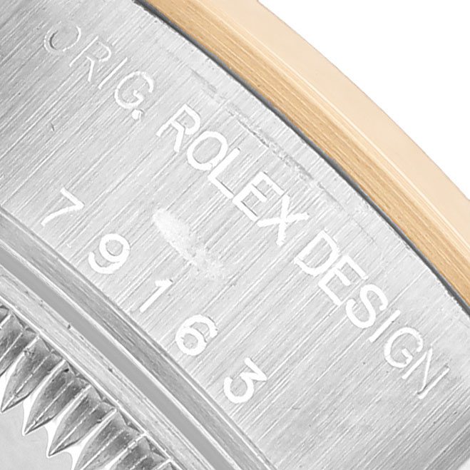 The image shows a close-up of the side of a Rolex Datejust 79163 Women's Steel and Gold (two tone) White Dial, highlighting the engraved model number and design details.
