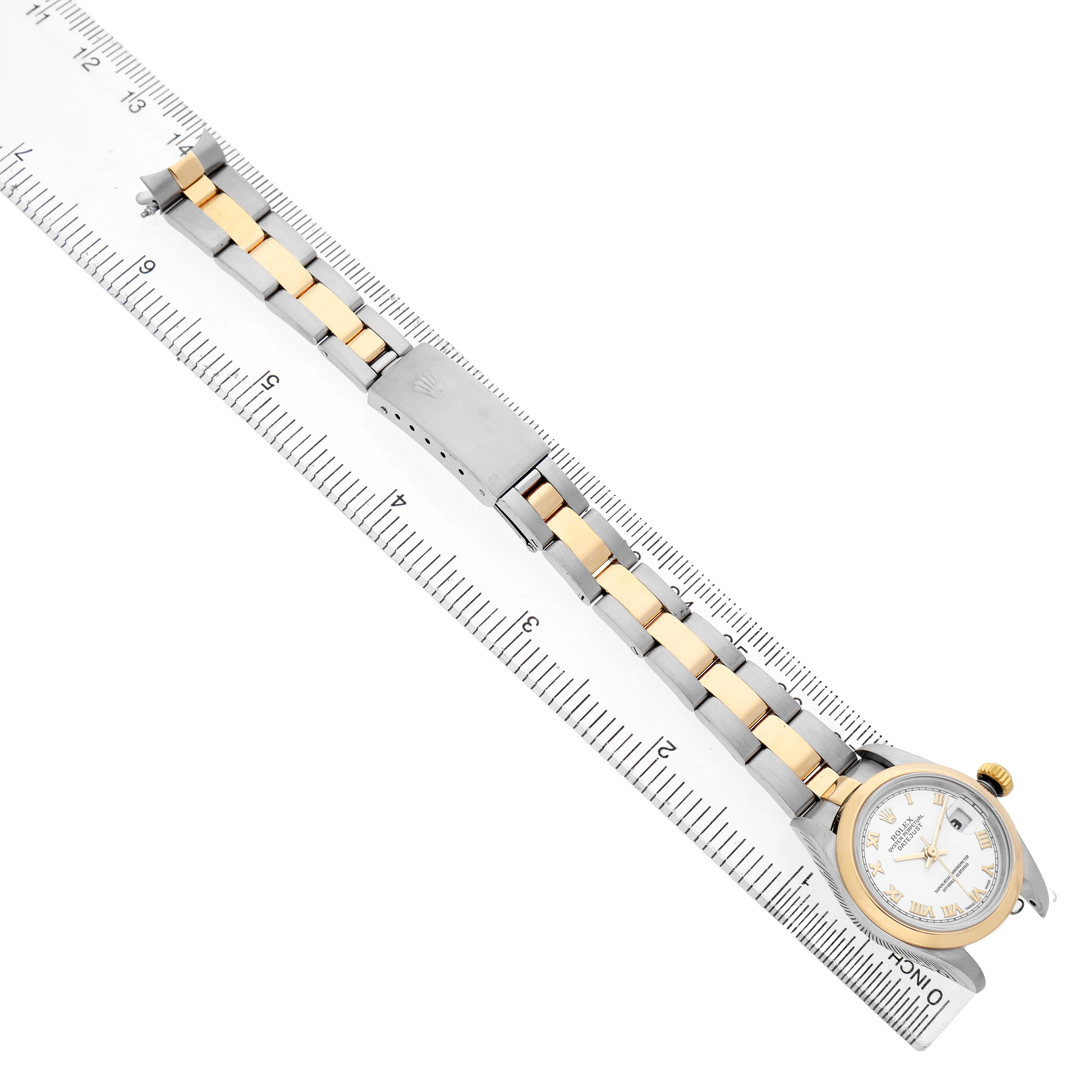 The Rolex Datejust 79163 Women's Steel and Gold (two tone) White Dial watch is shown from a top view, displaying the face and two-tone bracelet aligned with a ruler.