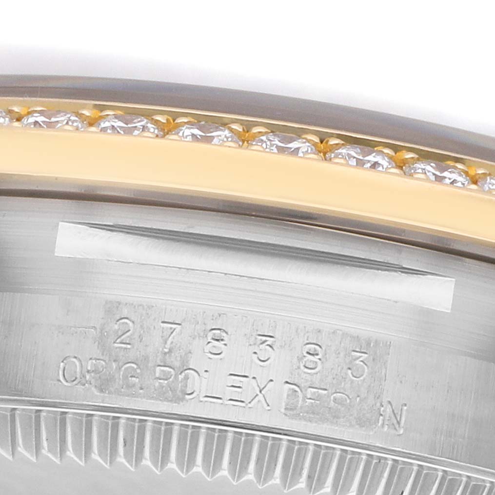 The image shows a close-up of the Rolex Mid-Size 278383 Women
s Steel and Gold (two tone) Silver Dial watch
s bezel and case edge, highlighting its diamond detailing and engraving.