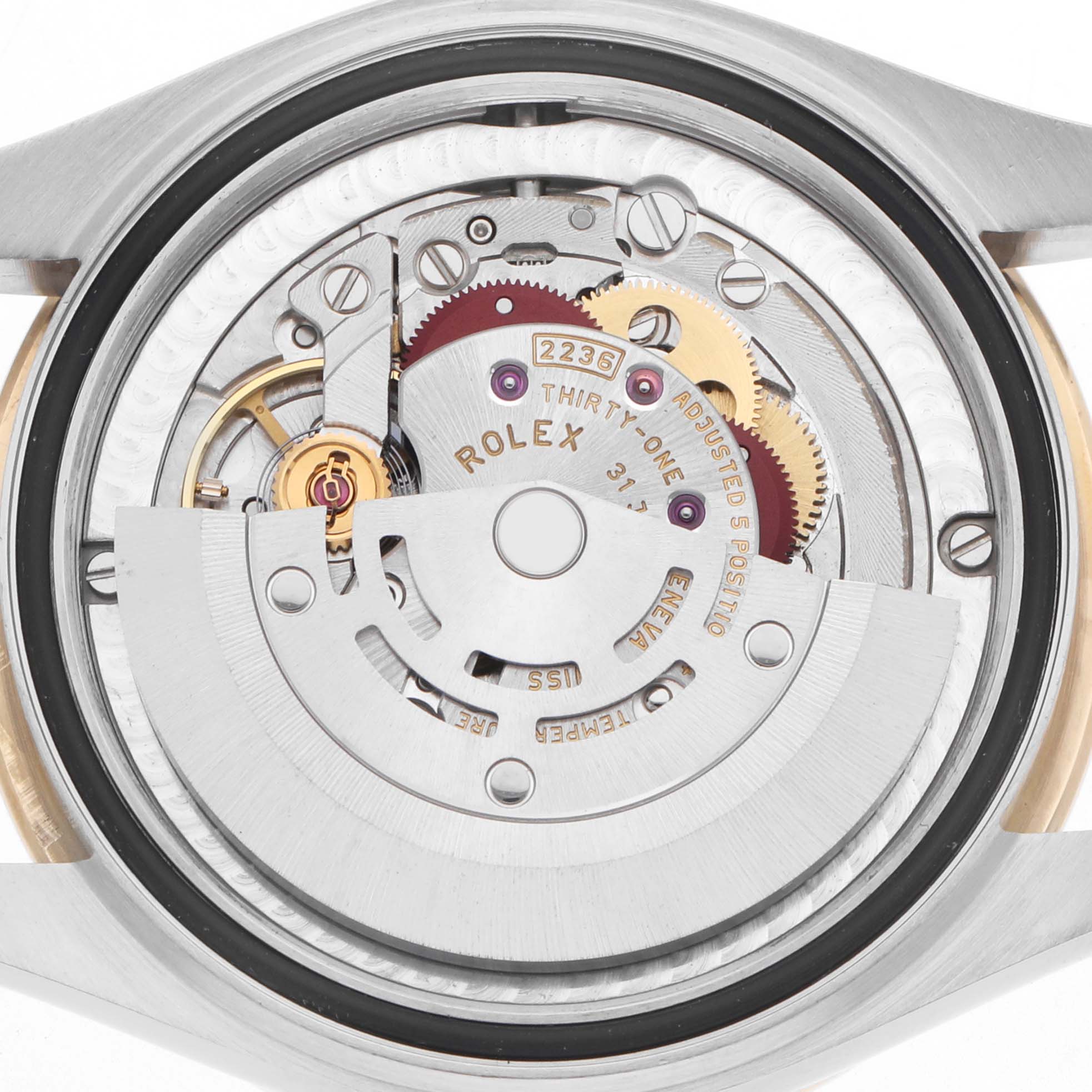 The image shows the movement of a Rolex Mid-Size 278383 Women
s Steel and Gold (two tone) Silver Dial watch from a top-down angle, highlighting gears and mechanisms.