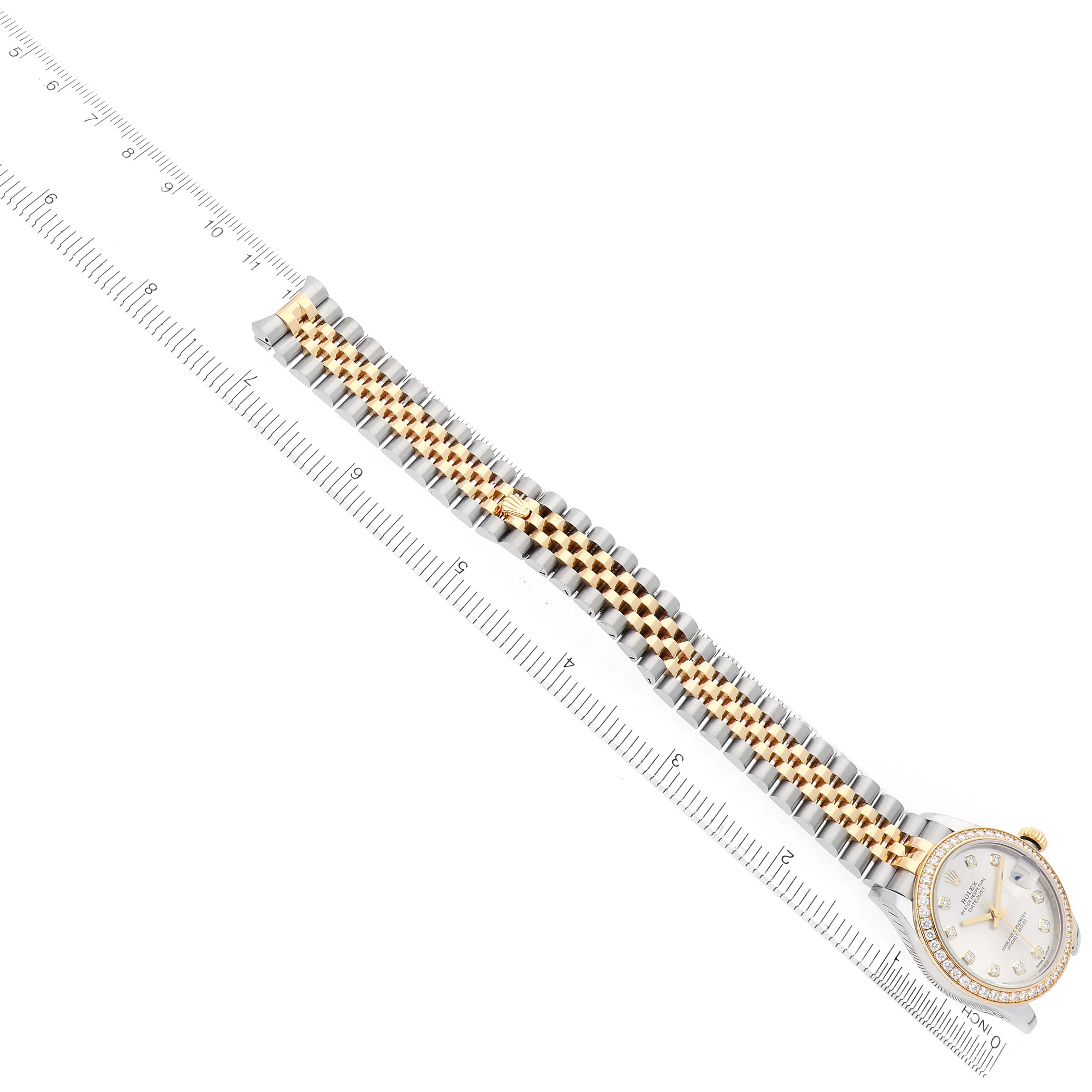 The Rolex Mid-Size 278383 Women
s Steel and Gold (two tone) Silver Dial watch is presented diagonally, displaying the full bracelet and partially visible face alongside a ruler for scale.