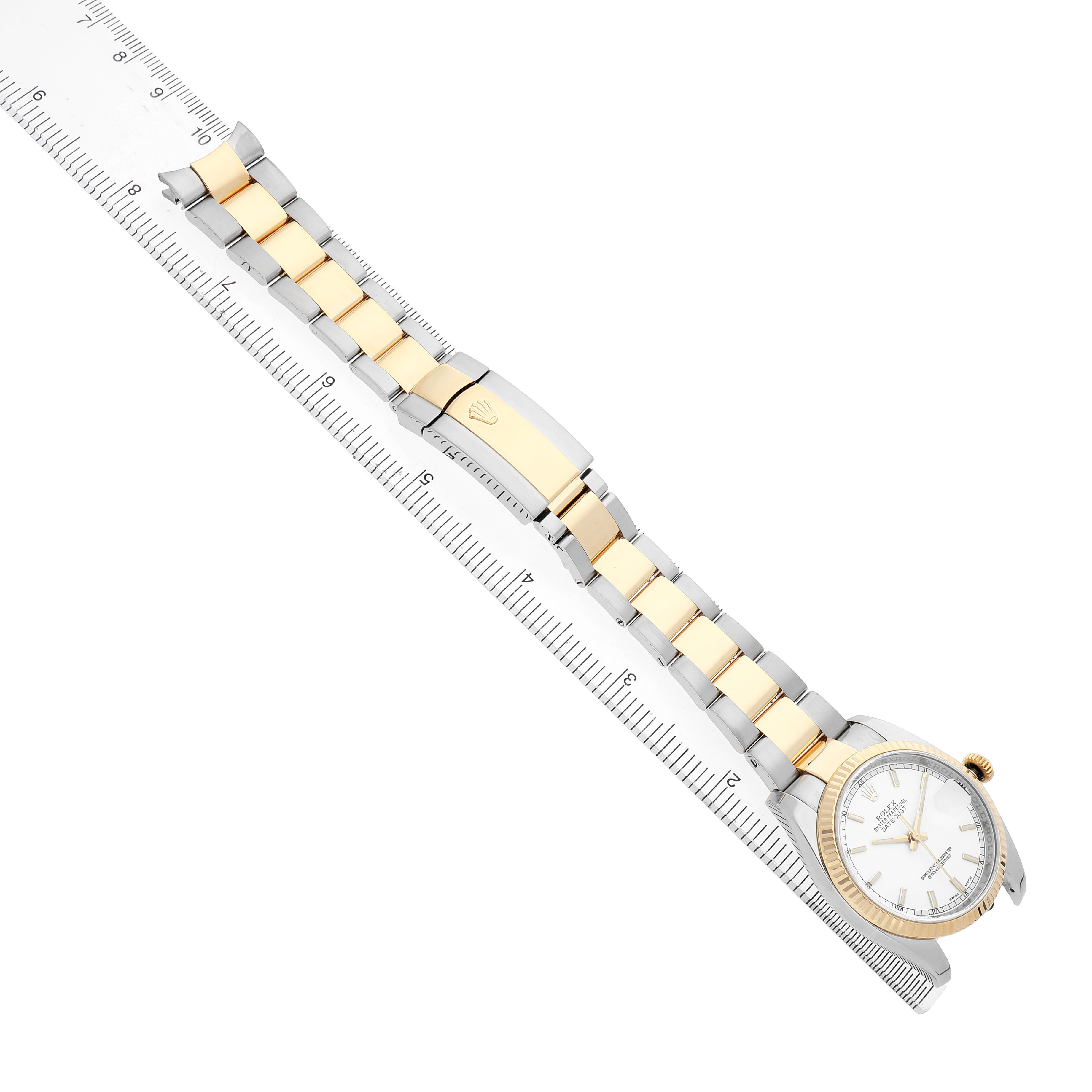 The Rolex Datejust 116233 Men's Steel and Gold (two tone) White Dial watch is shown from an overhead angle, featuring the dial, bezel, and full bracelet alongside a ruler.