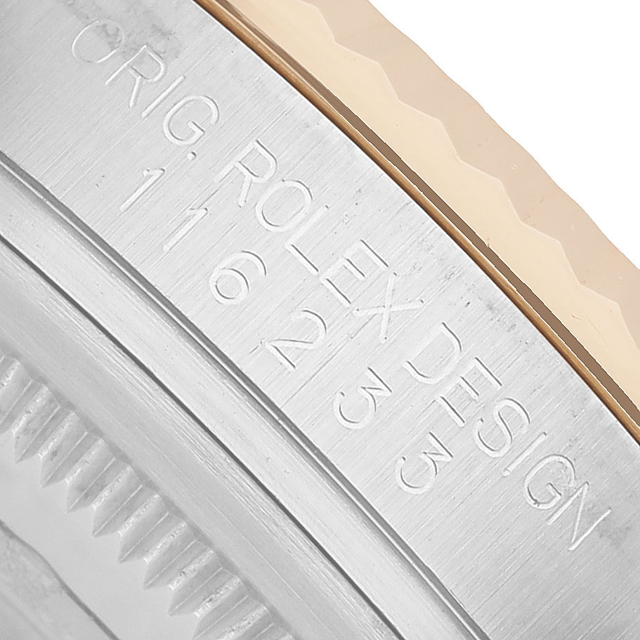 The image shows a close-up of the side of a Rolex Datejust 116233 Men's Steel and Gold (two tone) White Dial watch case, focusing on the engraved design details.