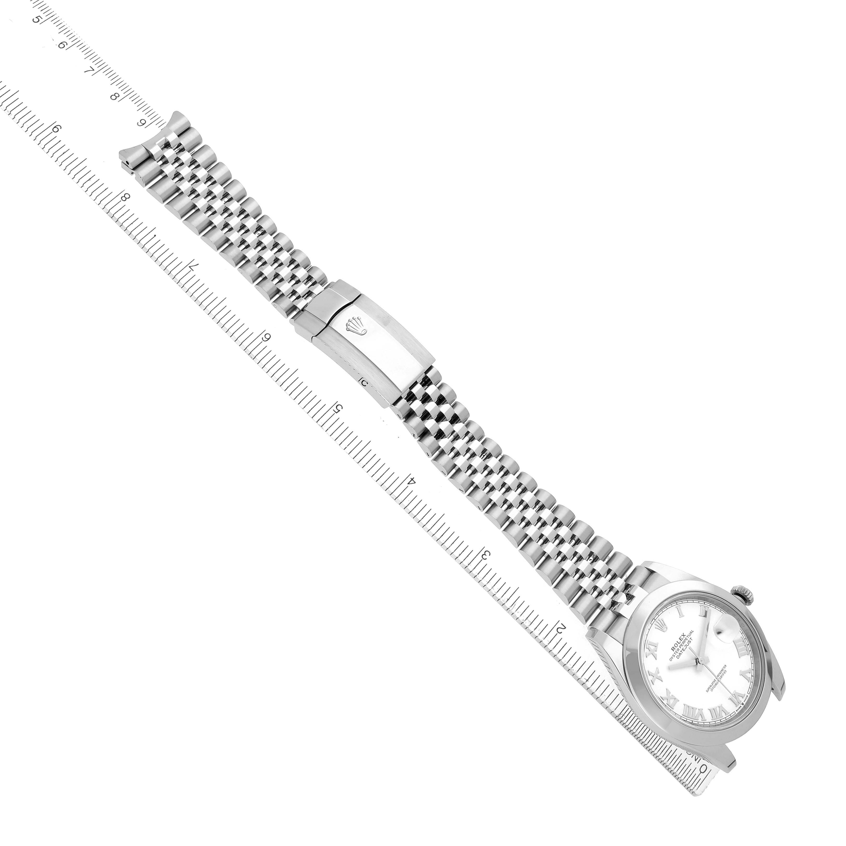 The Rolex Datejust 41 126300 Men
s Stainless Steel White Dial watch is shown from an overhead angle, highlighting the full bracelet and clasp next to a ruler.