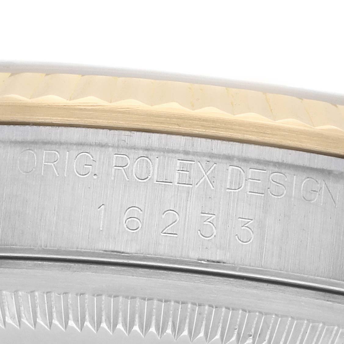 The image shows a close-up of a Rolex Datejust 16233 Men
s Steel and Gold (two tone) Champagne Dial
s engraved serial number and part of its bezel.