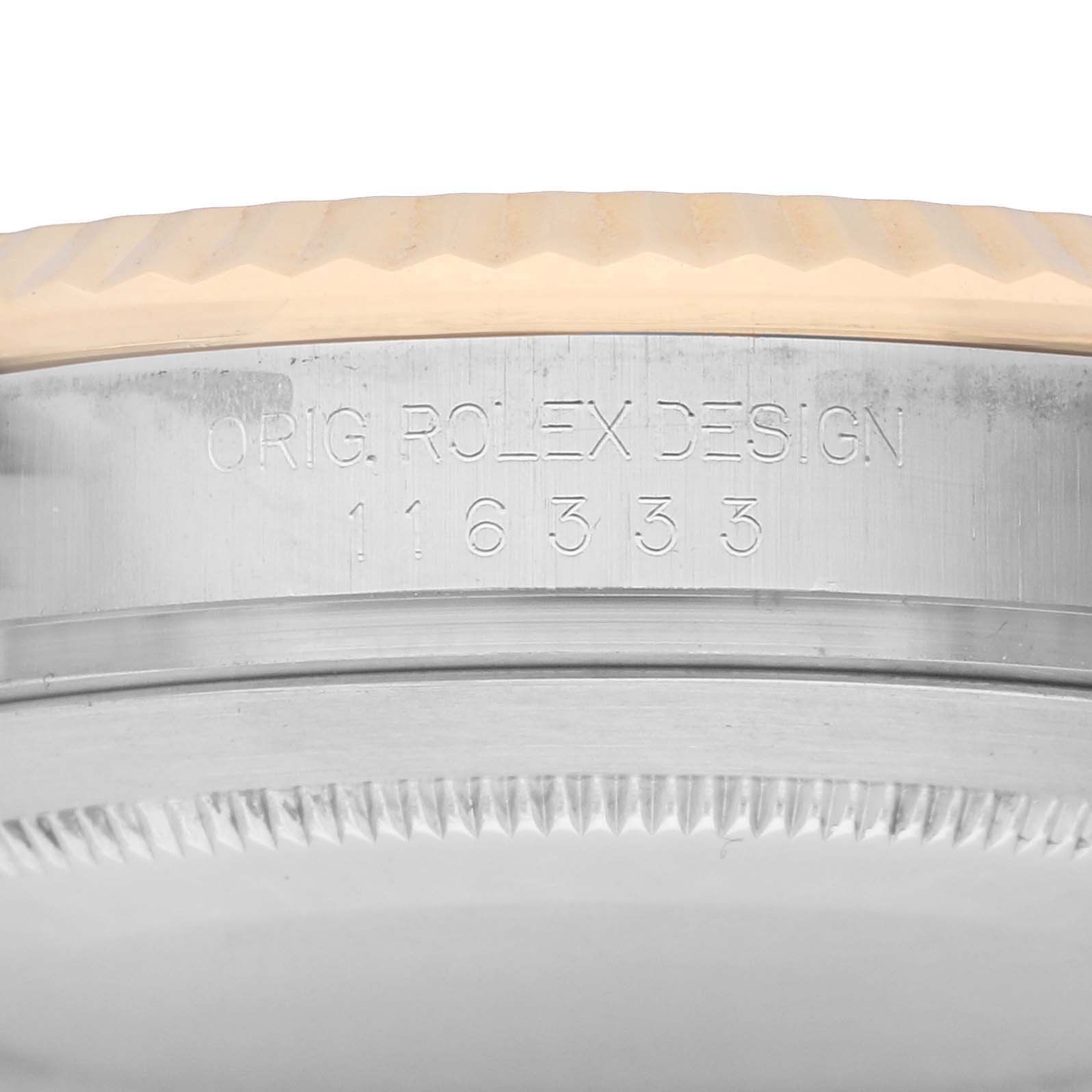 The image shows an angled close-up of the engraved side of a Rolex Datejust 41 116333 Men
s Steel and Gold (two tone) Silver Dial case, highlighting design details.