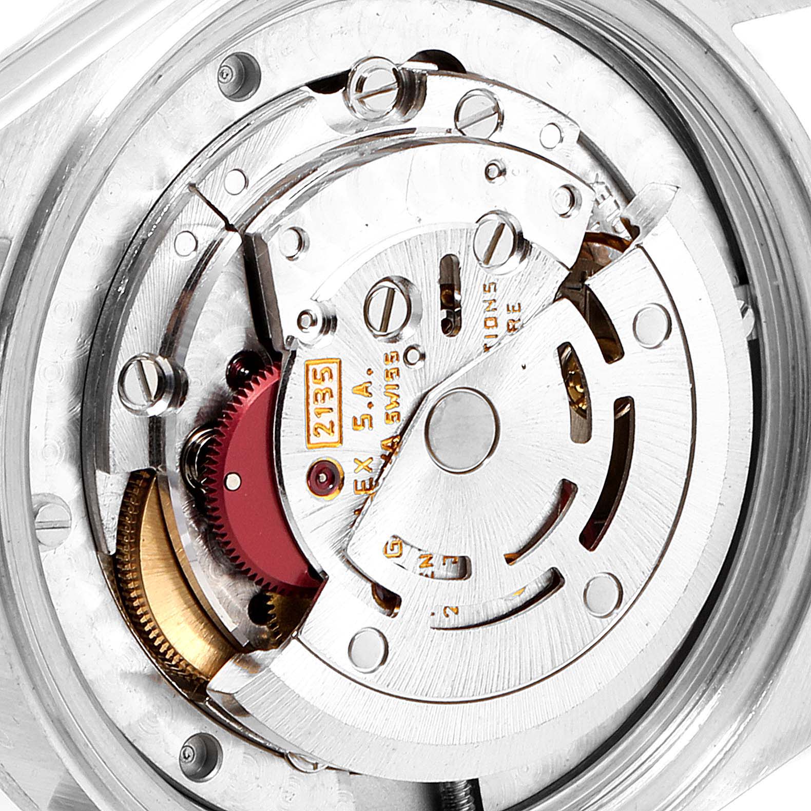 This image shows a detailed view of the movement mechanism inside a Mid-Size Rolex watch, highlighting gears, screws, and inscriptions.