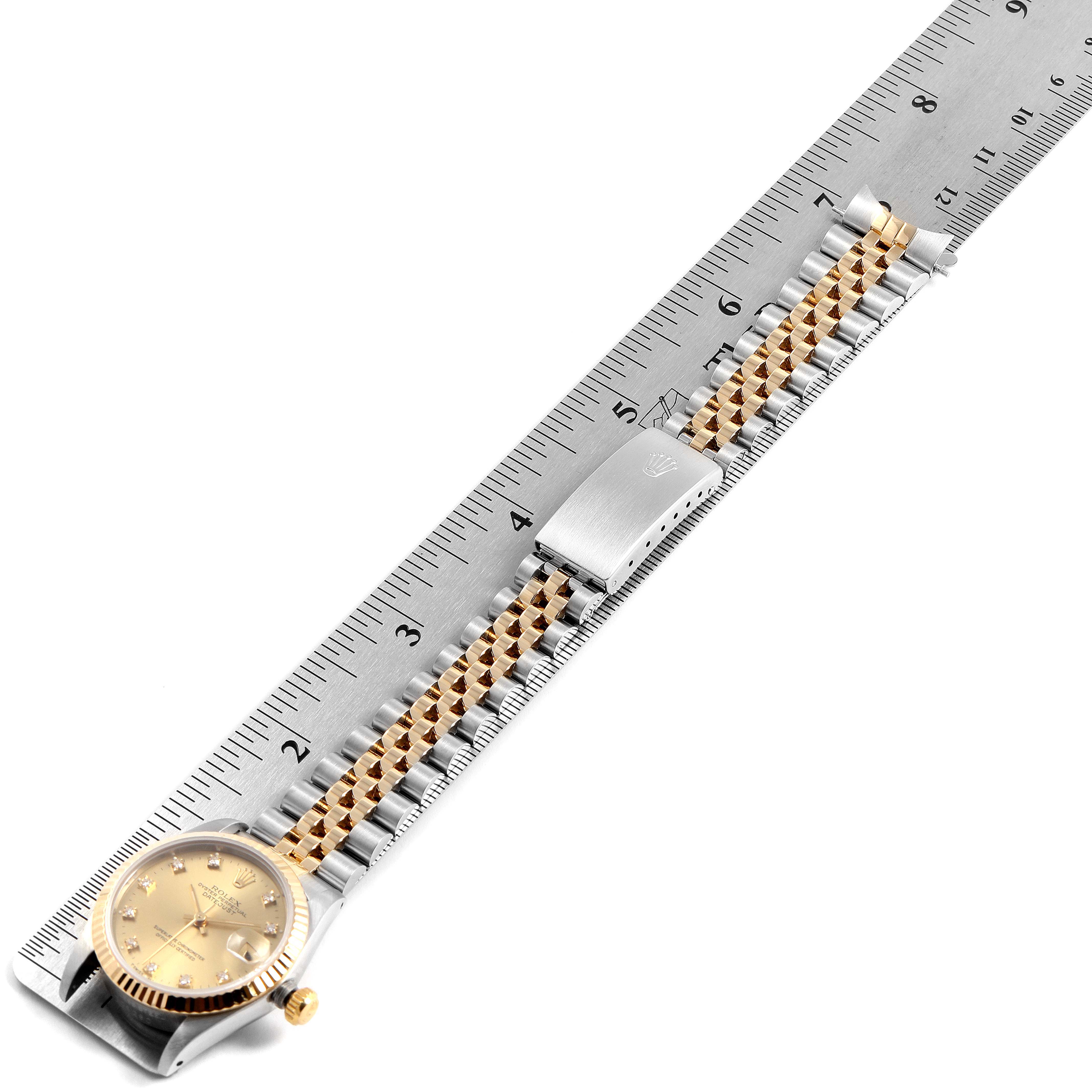 The image shows a top-down view of a Rolex Mid-Size 68273 Women
s Steel and Gold (two tone) Champagne Dial 68273 Women
s Steel and Gold (two tone) Champagne Dial model, with its band extended alongside a ruler.