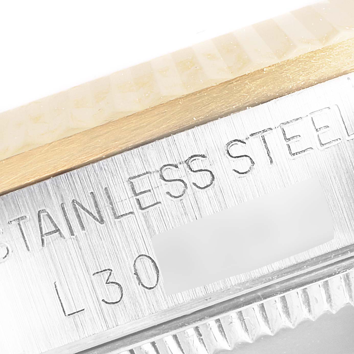 This close-up image shows the side of a Rolex Mid-Size 68273 Women
s Steel and Gold (two tone) Champagne Dial 68273 Women
s Steel and Gold (two tone) Champagne Dial model watch, highlighting the stainless steel case and part of the bezel with engraved text.