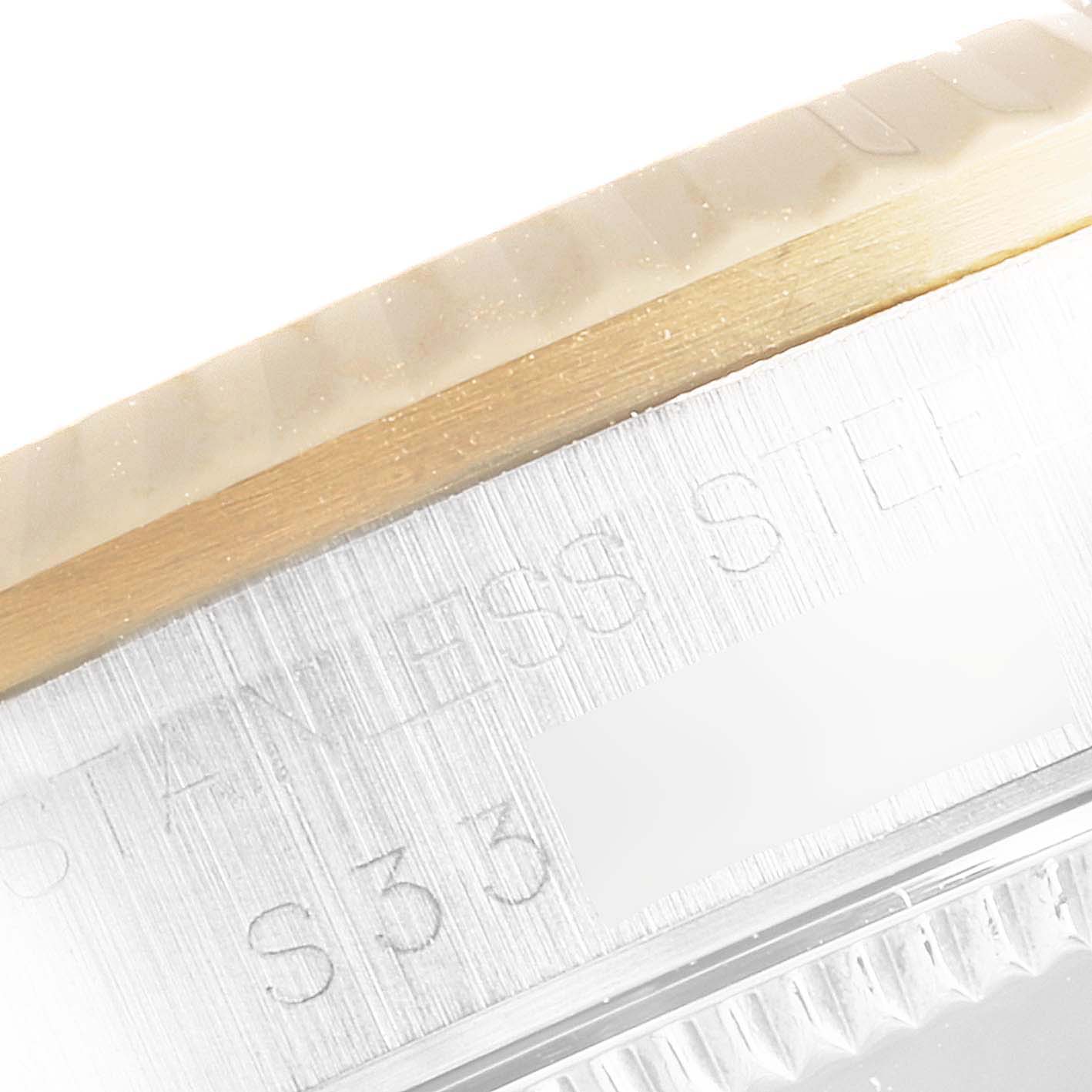 The image shows a close-up of the side of a Rolex Mid-Size 68273 Women
s Steel and Gold (two tone) Champagne Dial 68273 Women
s Steel and Gold (two tone) Champagne Dial model watch, focusing on the edge of the bezel and part of the case with engraved text.