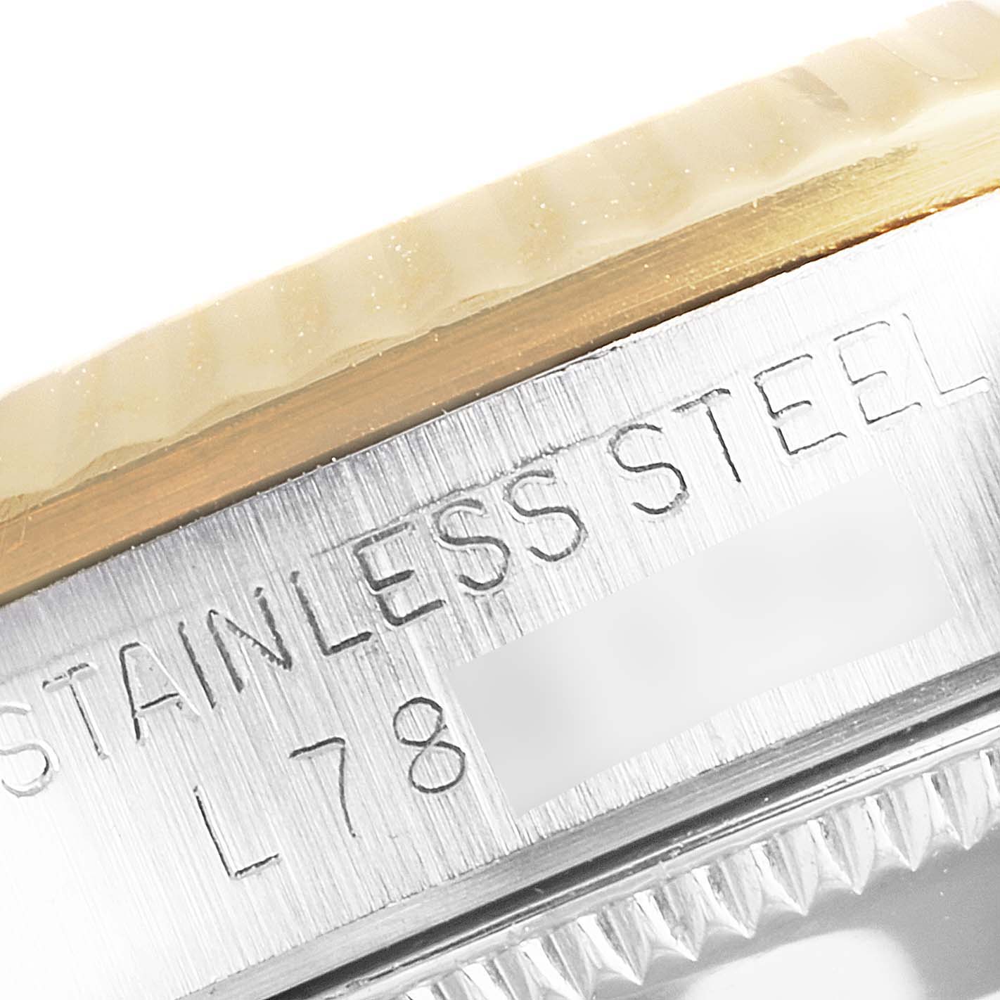 The image shows a close-up of the bezel and case side of a Mid-Size Rolex watch, highlighting its stainless steel and engraving details.