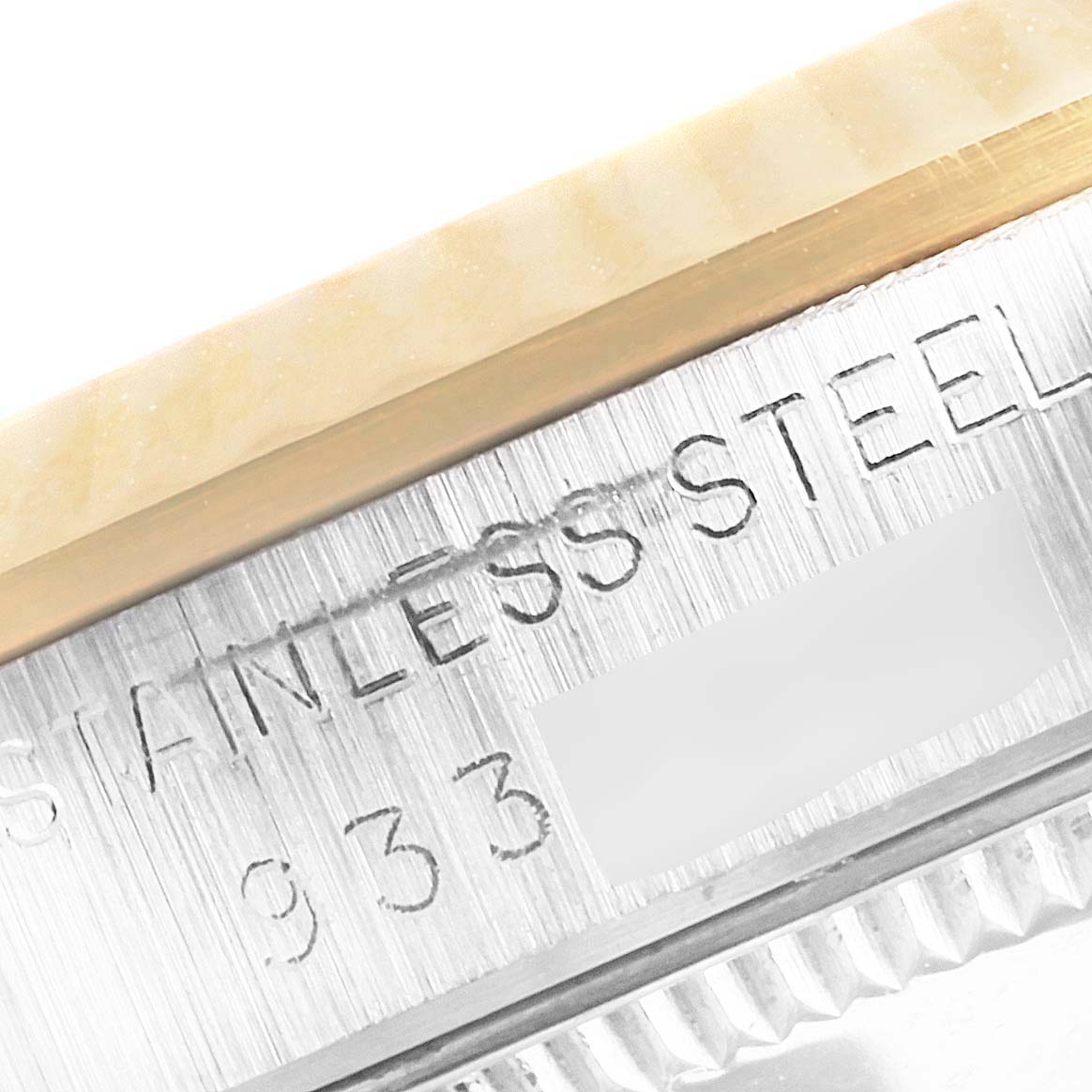 This close-up of the Mid-Size Rolex watch shows part of the bezel and the engraved "STAINLESS STEEL" text on the case.