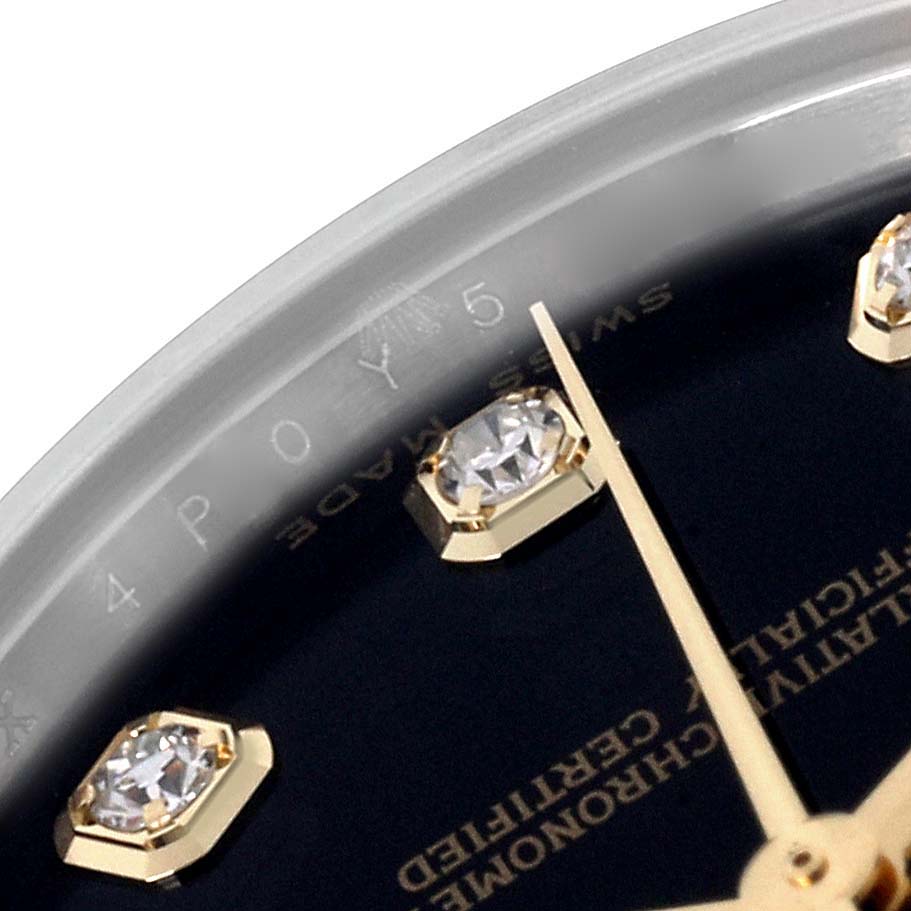 This close-up of the Rolex Mid-Size 178273 Women's Steel and Gold (two tone) Black Dial 178273 Women's Steel and Gold (two tone) Black Dial watch shows the dial with diamond hour markers and a partial view of the hands.