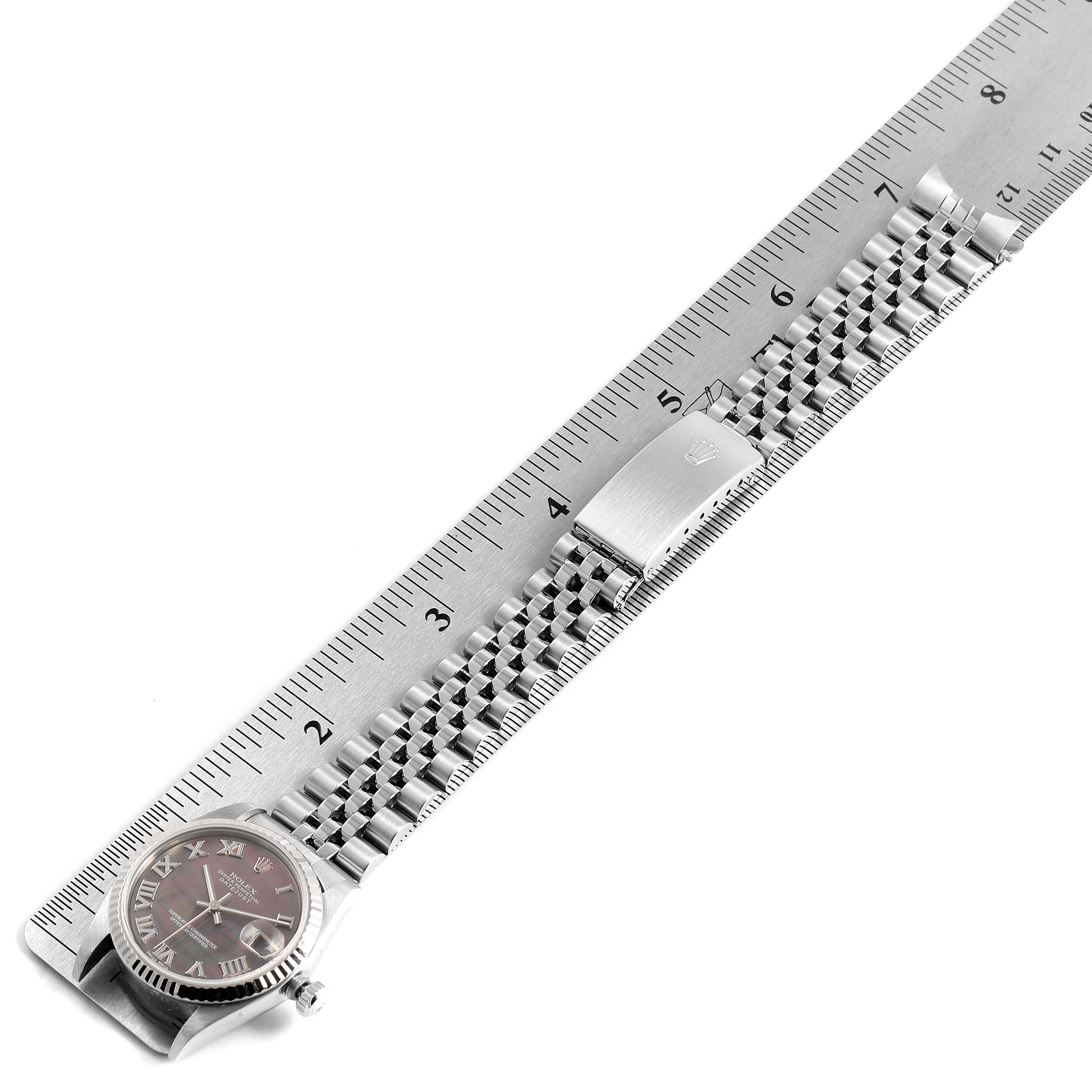 The image shows a Rolex Mid-Size 78274 Women
s Stainless Steel Mother of Pearl Dial 78274 Women
s Stainless Steel Mother of Pearl Dial model watch from a top-down angle, including the watch face, bracelet, and folding clasp alongside a ruler for scale.