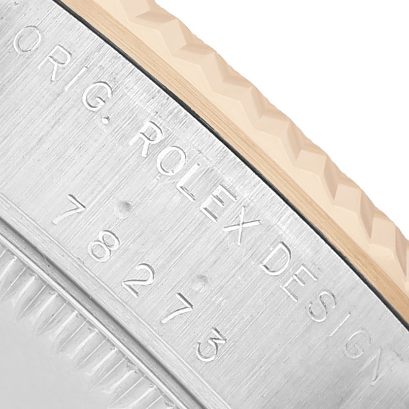 The image shows a close-up of the case edge and bezels of the Rolex Datejust 78273 Women's Steel and Gold (two tone) Red Dial, highlighting the engraved markings.