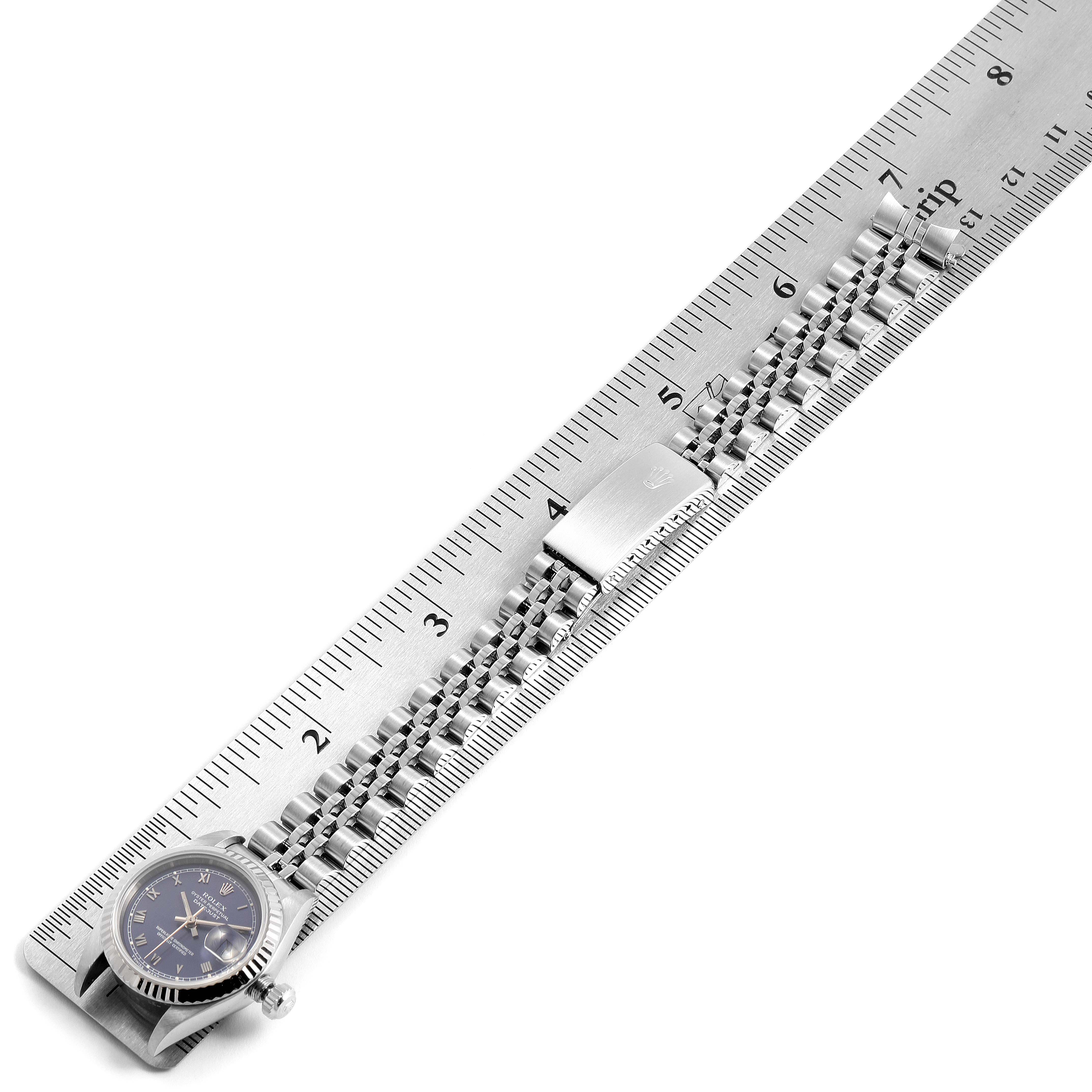 The image shows a sideways view of a Rolex Datejust 69174 Women's Stainless Steel Blue Dial 69174 Women's Stainless Steel Blue Dial watch with its bracelet placed along a ruler for measurement.