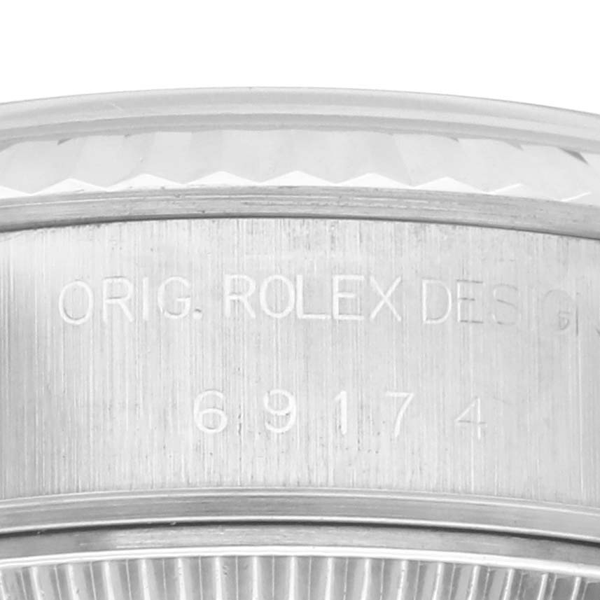 The image shows the side engraving of a Rolex Datejust 69174 Women's Stainless Steel Silver Dial 69174 Women's Stainless Steel Silver Dial watch case, featuring model and serial details.