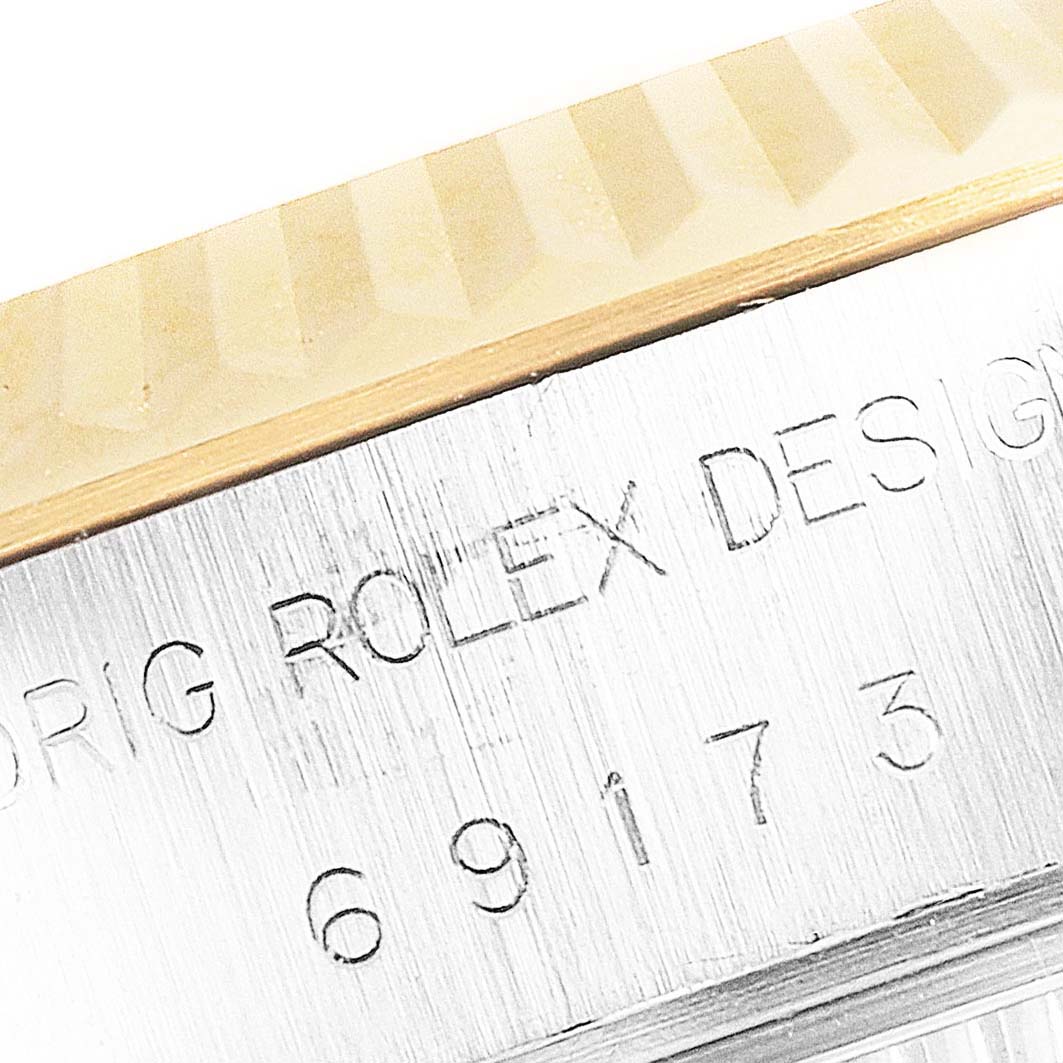 The image shows a close-up of the side of a Rolex Datejust 69173 Women's Steel and Gold (two tone) Silver Dial 69173 Women's Steel and Gold (two tone) Silver Dial watch, focusing on the bezel and engraved case.