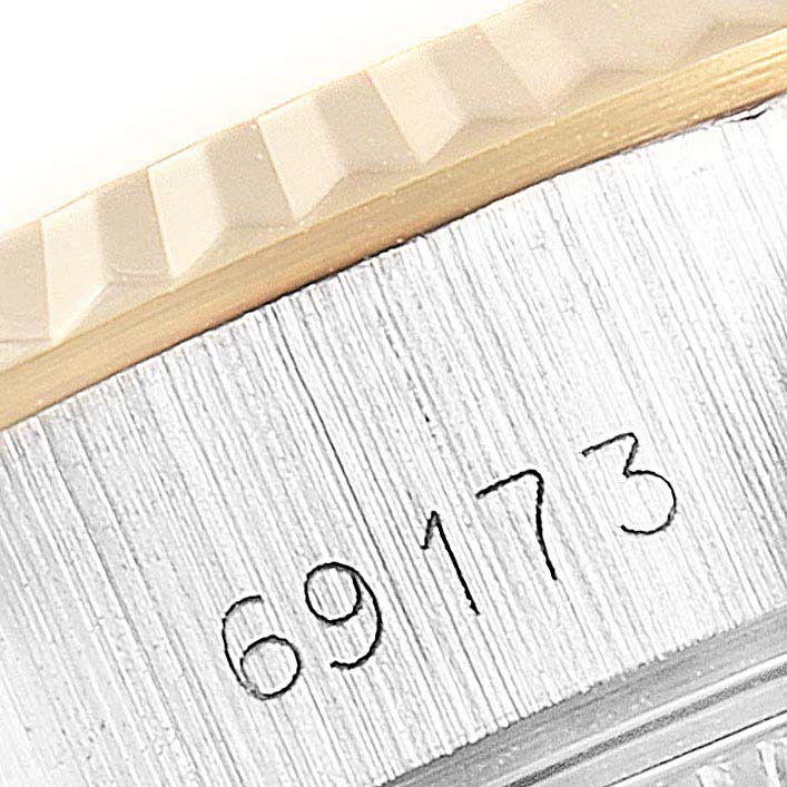 The image shows a close-up of the serial number and part of the textured bezel of a Rolex Datejust 69173 Women
s Steel and Gold (two tone) Black Dial 69173 Women
s Steel and Gold (two tone) Black Dial watch.
