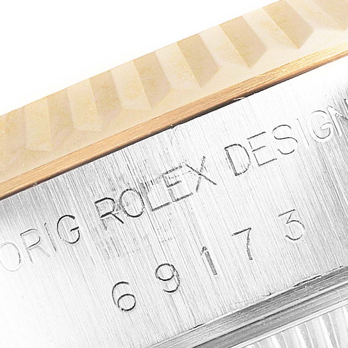 This close-up shot of the Rolex Datejust 69173 Women's Steel and Gold (two tone) White Dial 69173 Women's Steel and Gold (two tone) White Dial shows part of the fluted bezel and the engraved model details on the case side.