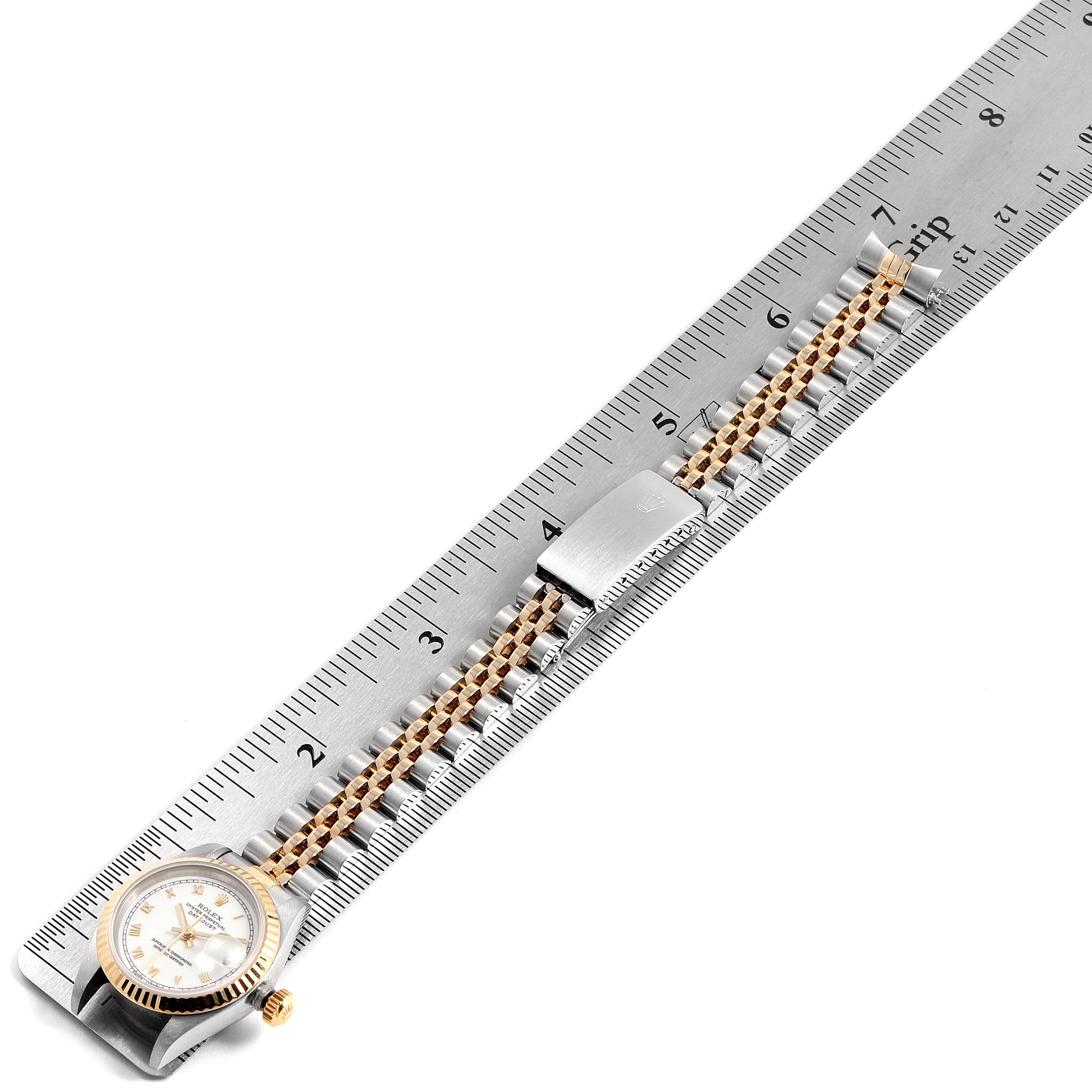 The Rolex Datejust 69173 Women's Steel and Gold (two tone) White Dial 69173 Women's Steel and Gold (two tone) White Dial watch is shown in a horizontal angle with its face, bezel, bracelet, and clasp visible, placed alongside a ruler.