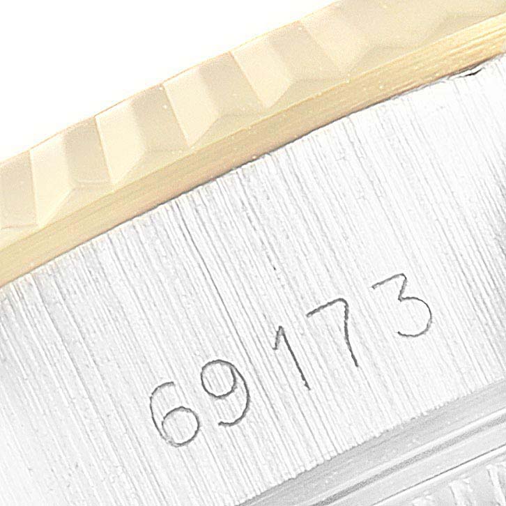 The image shows a close-up of the stainless steel case and engraved serial number of a Rolex Datejust 69173 Women's Steel and Gold (two tone) Silver Dial 69173 Women's Steel and Gold (two tone) Silver Dial model, including part of the bezel.