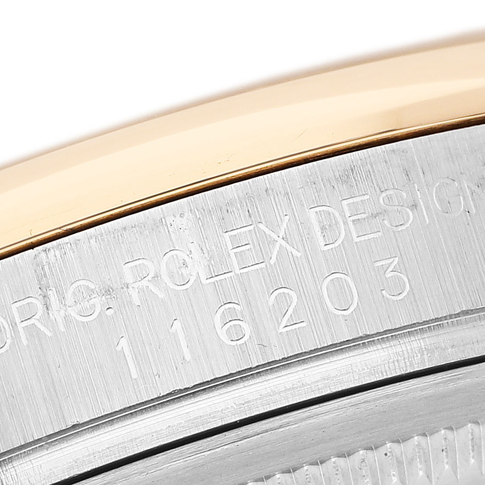 The image shows a close-up of the bezel and engraved serial number on a Rolex Datejust 116203 Men's Steel and Gold (two tone) Grey Dial watch.