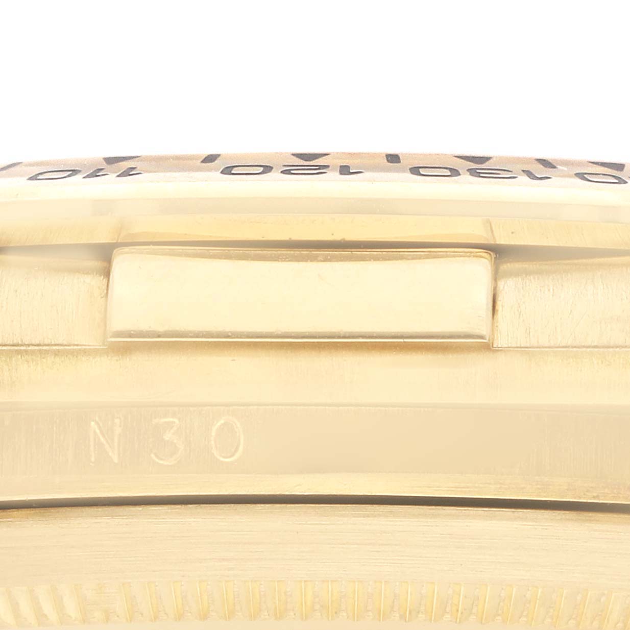 The image shows a side view of the Rolex Daytona 16518 Men
s Yellow Gold White Dial watch, highlighting the bezel and part of the case.