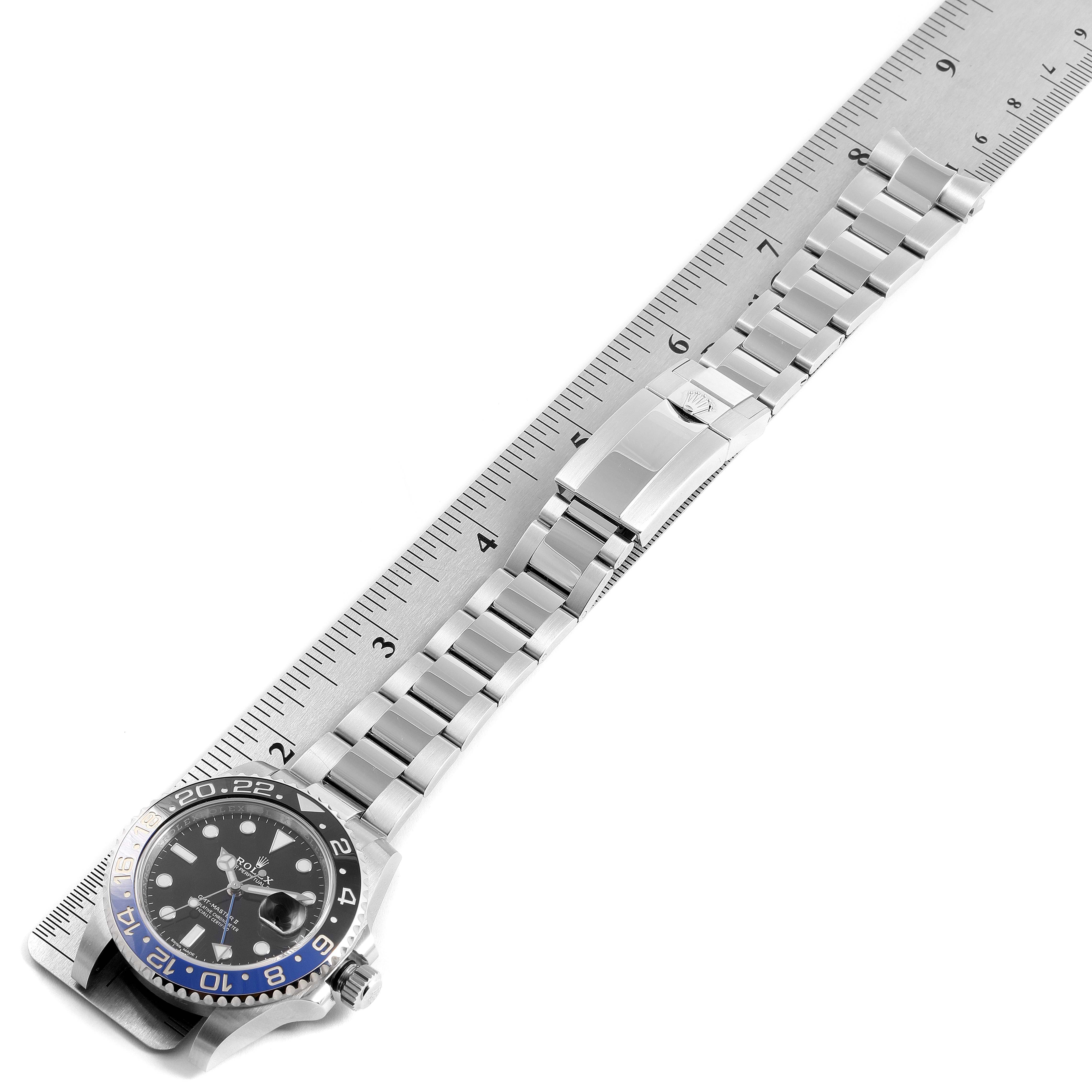The image shows a Rolex GMT-Master 116710 Men
s Stainless Steel Black Dial 116710 Men
s Stainless Steel Black Dial watch with the face and bracelet aligned next to a ruler for measurement.