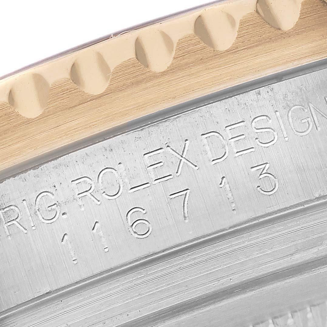 The image shows a close-up of the bezel and engraved design number on a Rolex GMT-Master 116713 Men's Steel and Gold (two tone) Black Dial 116713 Men's Steel and Gold (two tone) Black Dial watch.