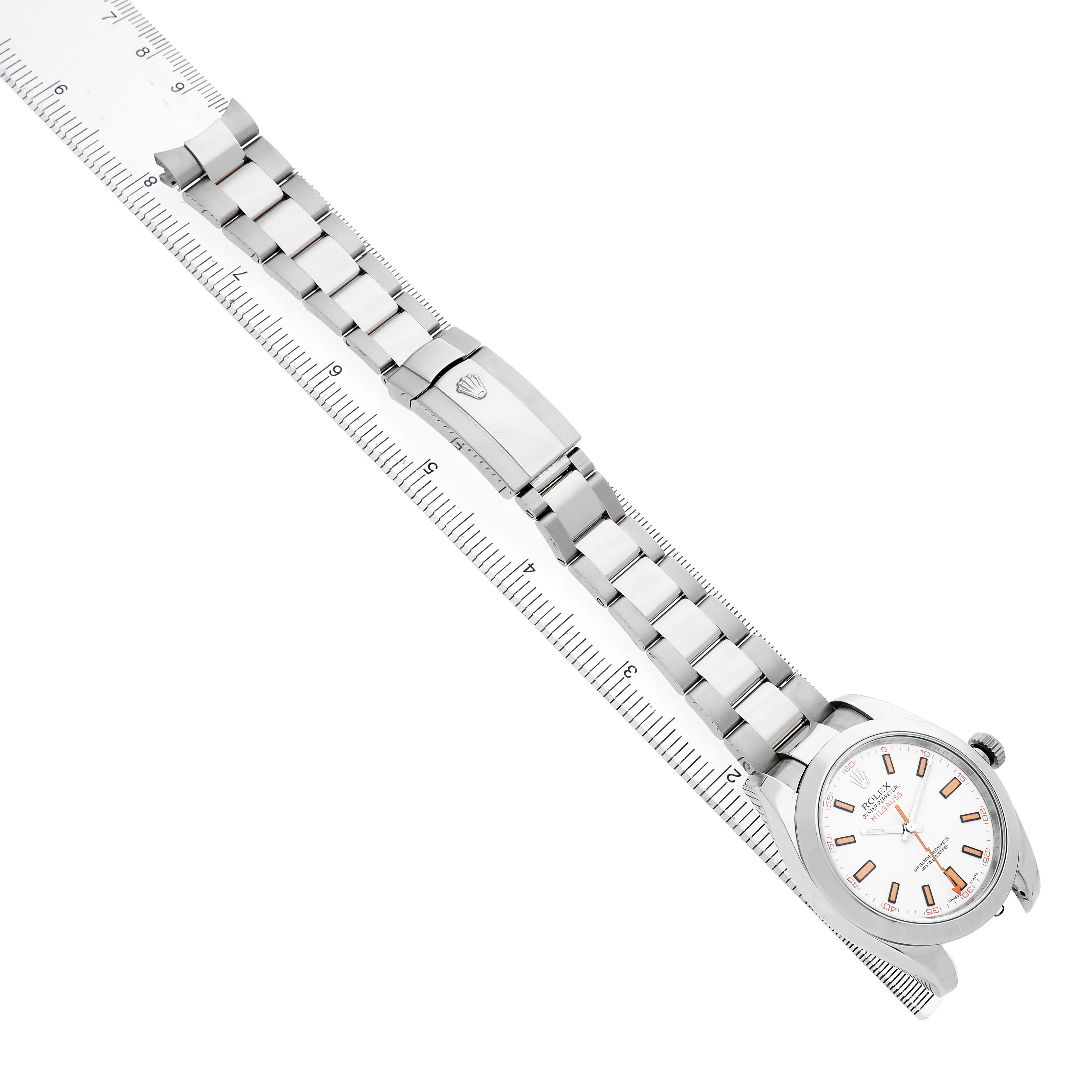 The Rolex Milgauss 116400 Men's Stainless Steel White Dial watch is shown from a top angle with the face and entire bracelet visible, alongside a ruler.